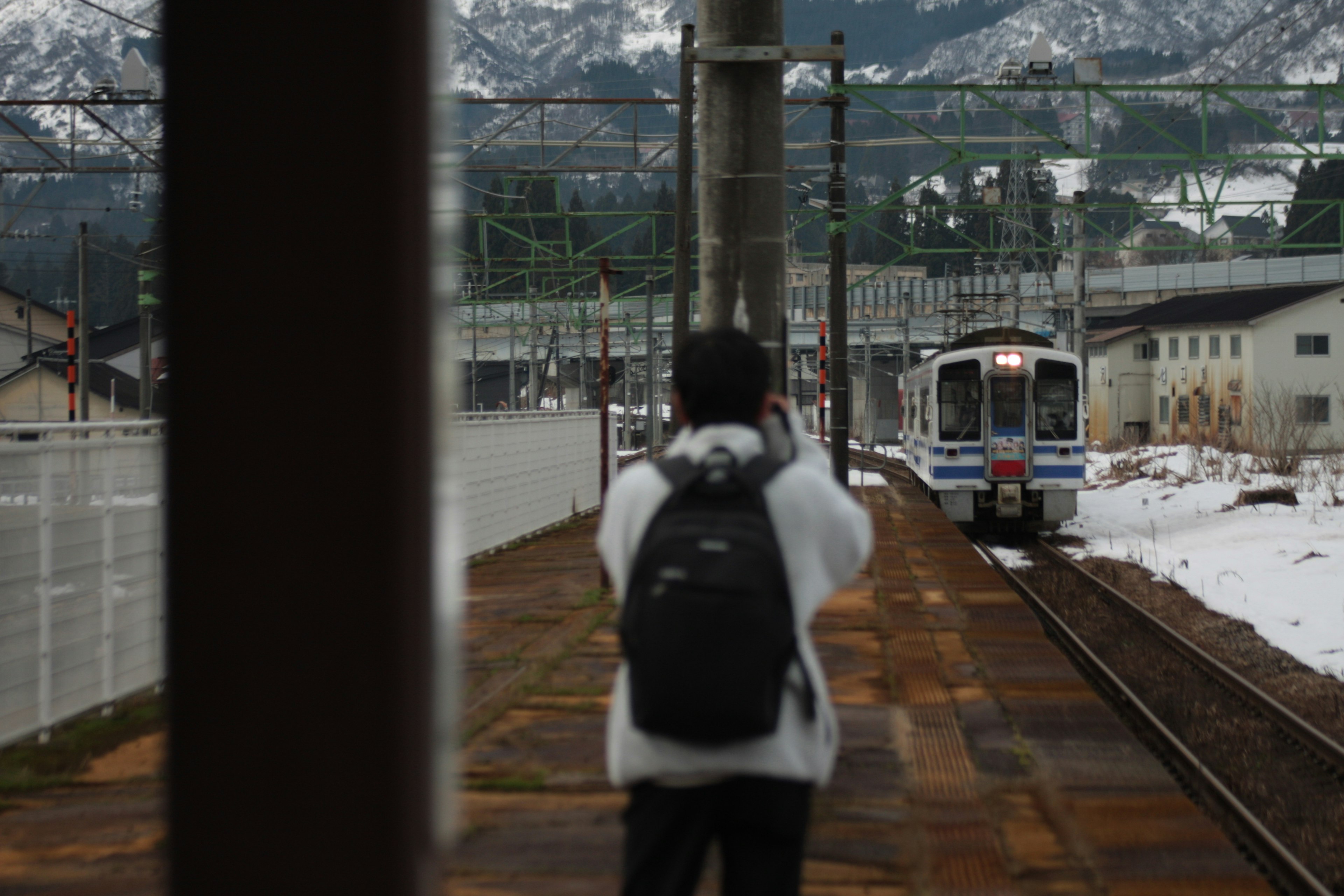 A person waiting for a train in a snowy landscape