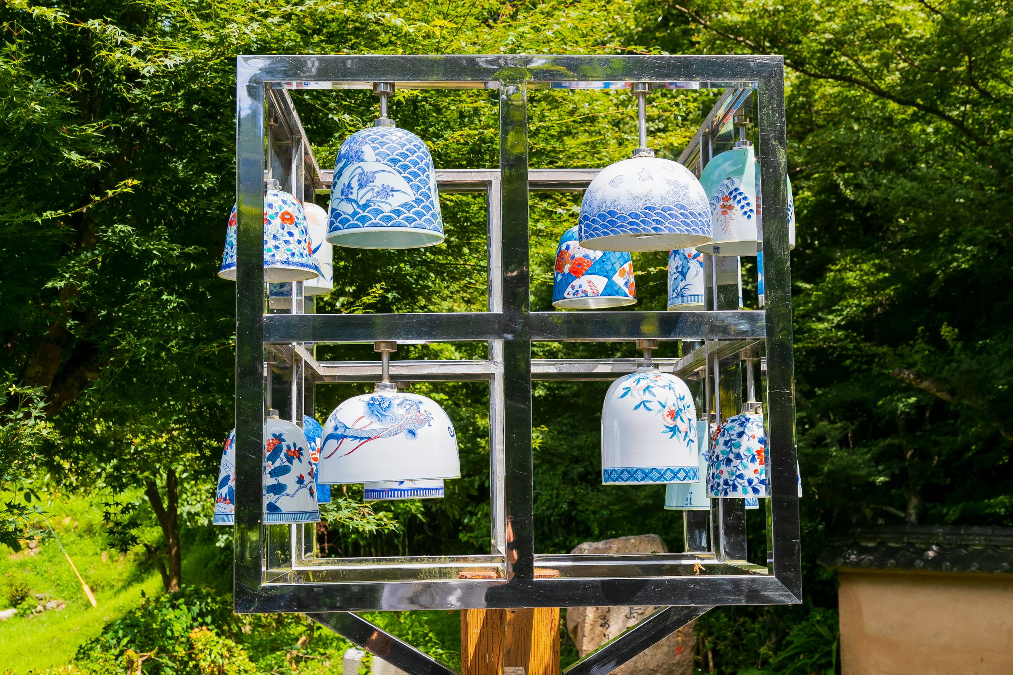 Beautiful blue and white wind chimes hanging from a metal frame