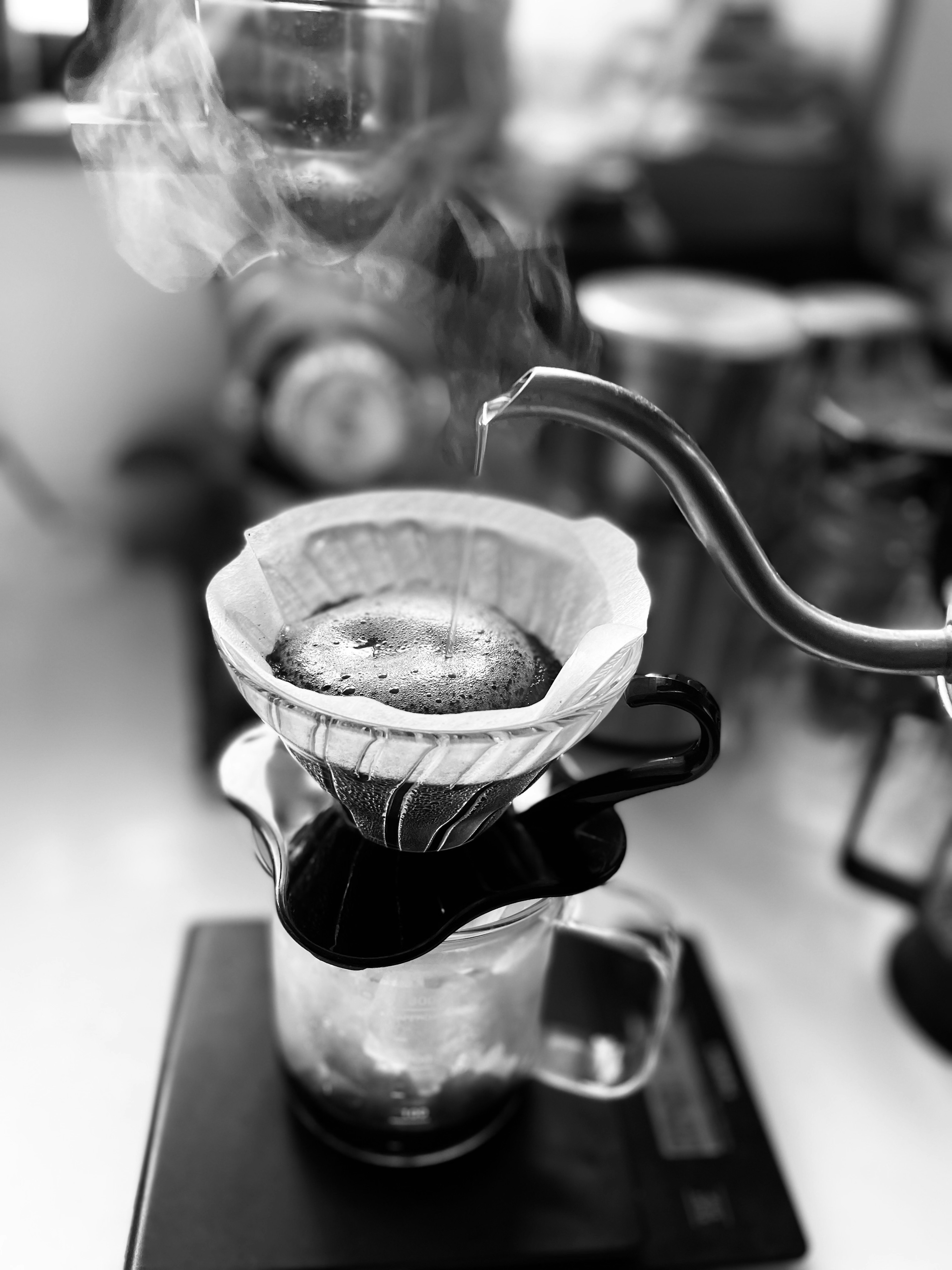 Black and white image of coffee being brewed with steam rising