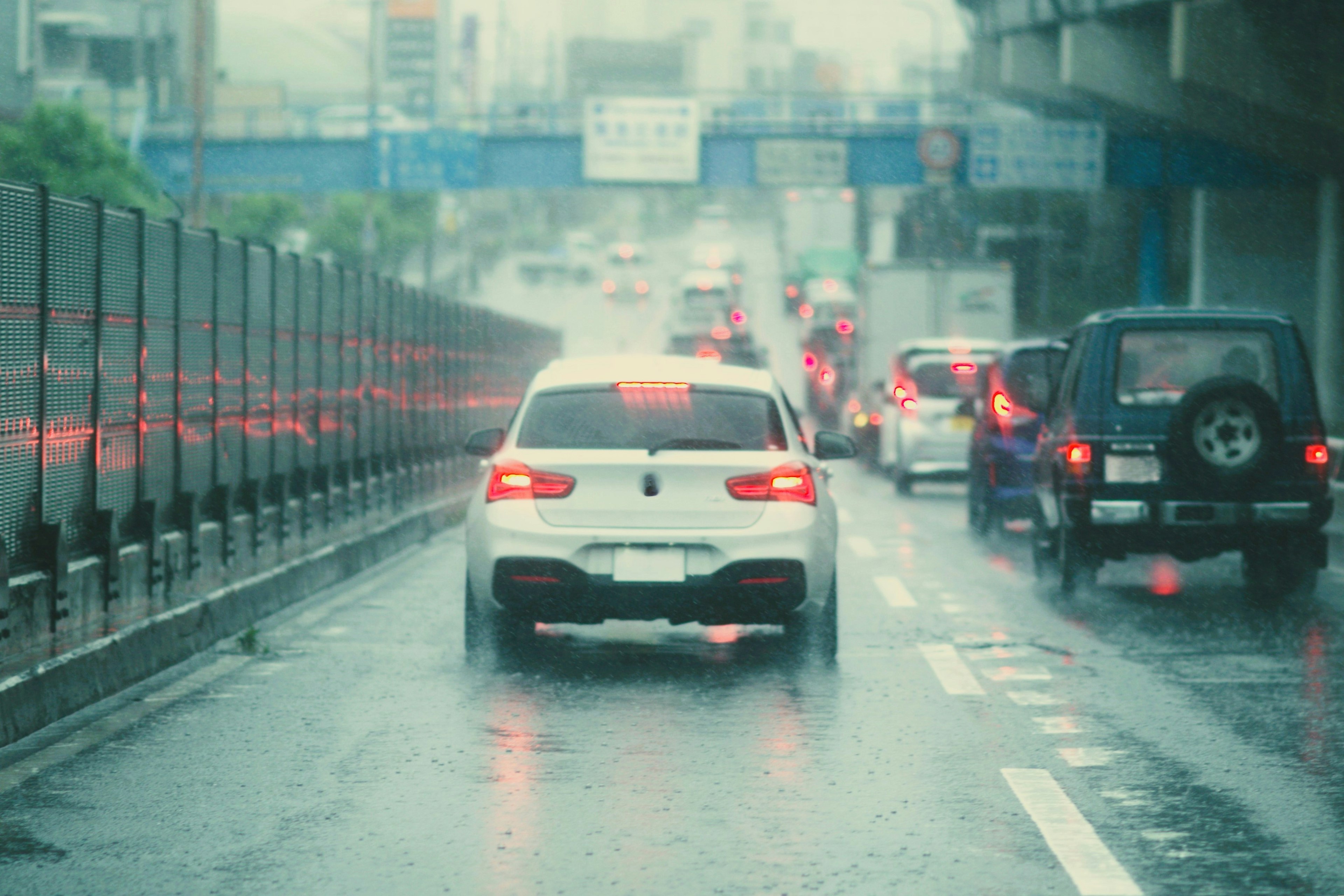 Vue arrière d'une voiture circulant sous la pluie avec du trafic