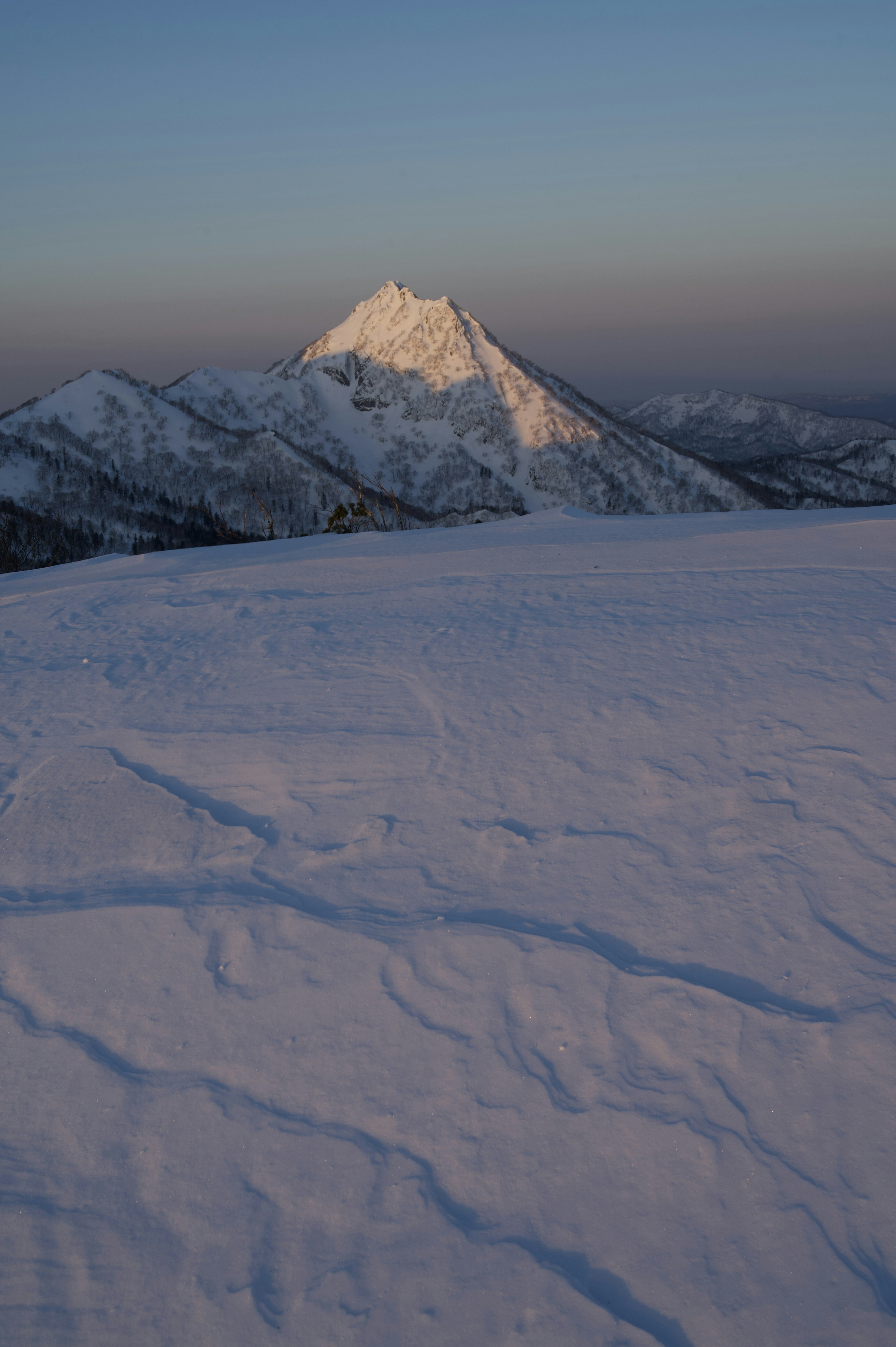 Schneebedeckte Berglandschaft mit einem markanten Gipfel