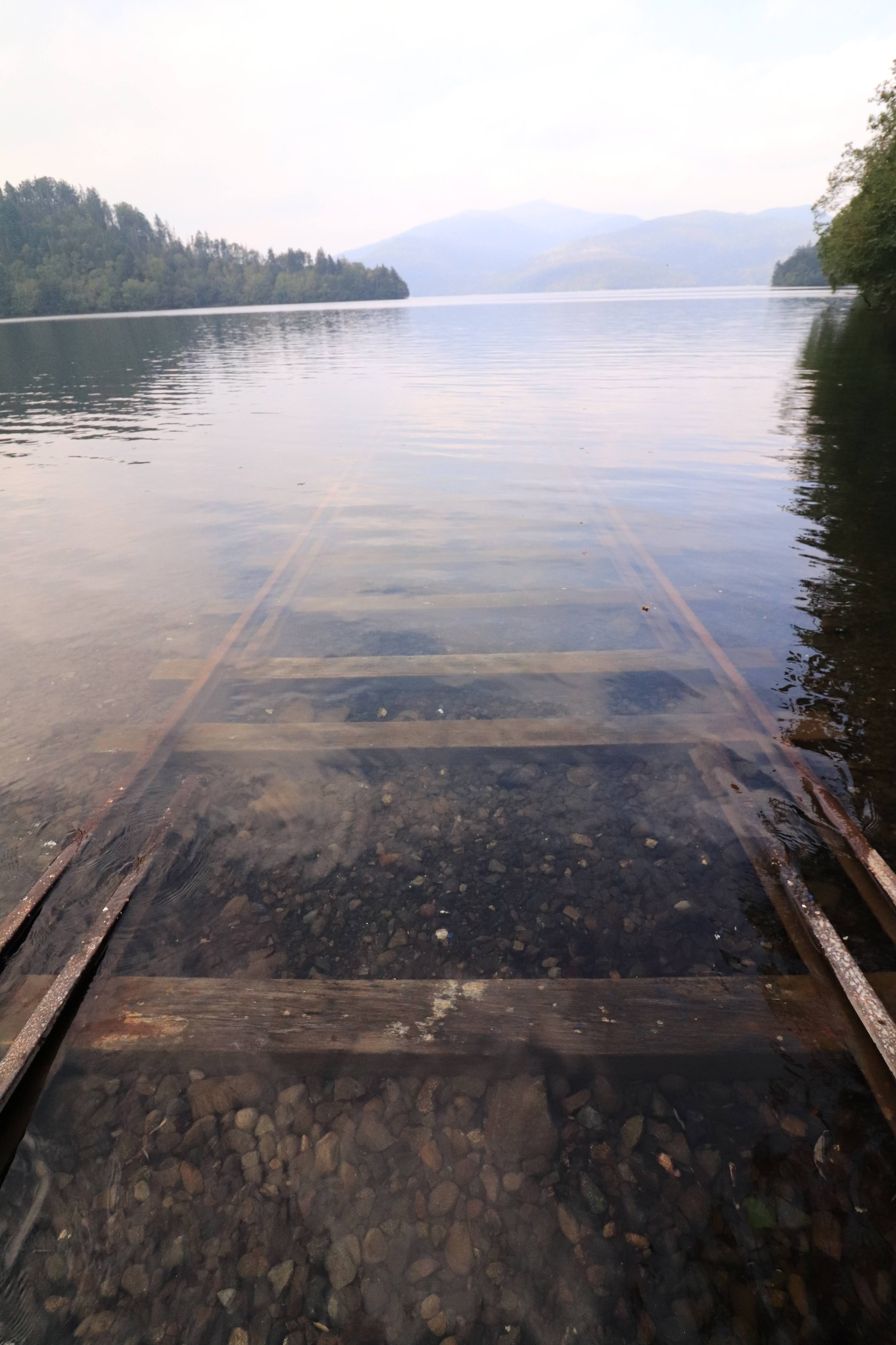 Pontile in legno parzialmente sommerso in un lago calmo