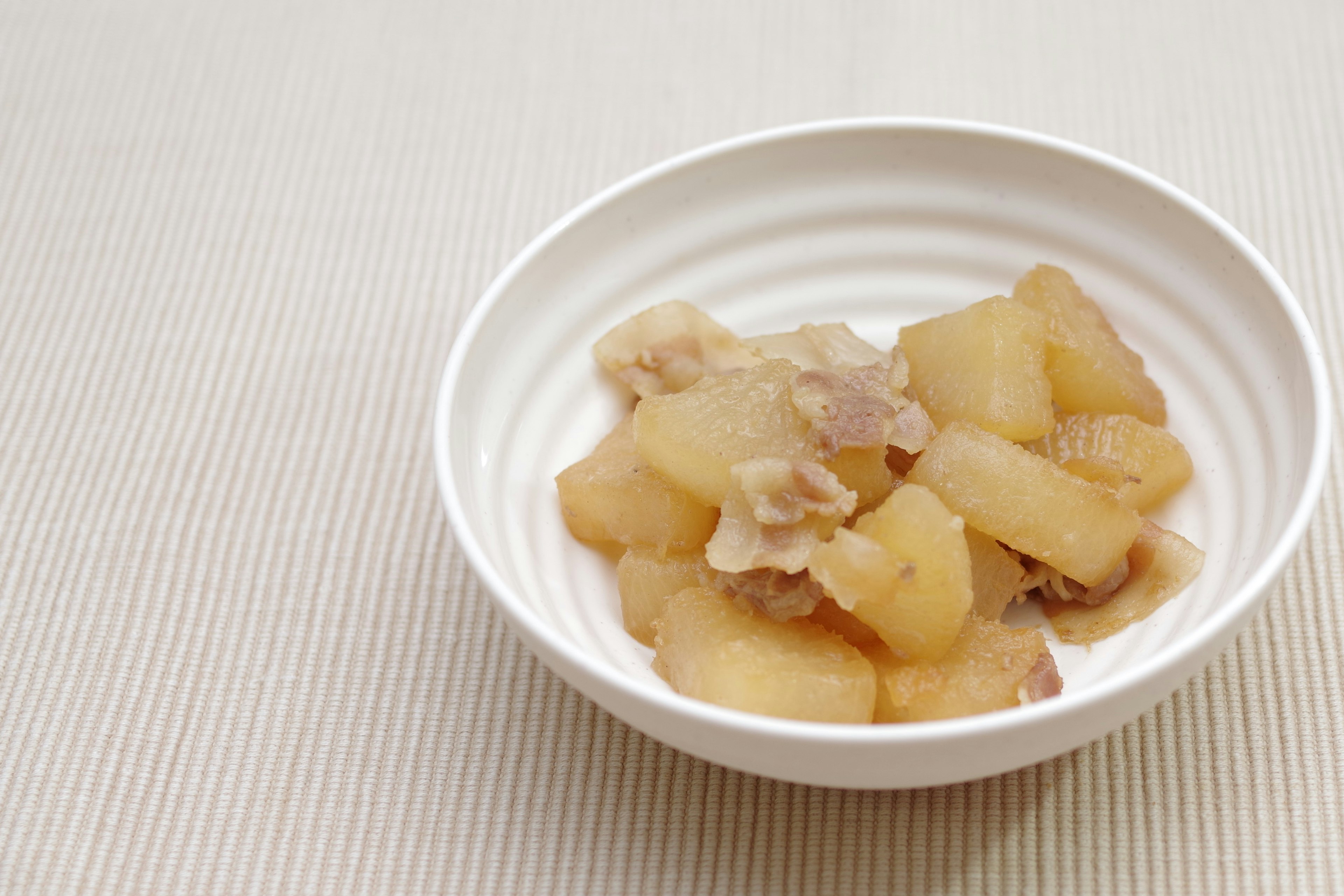 Ragù di daikon e carne servito in una ciotola bianca