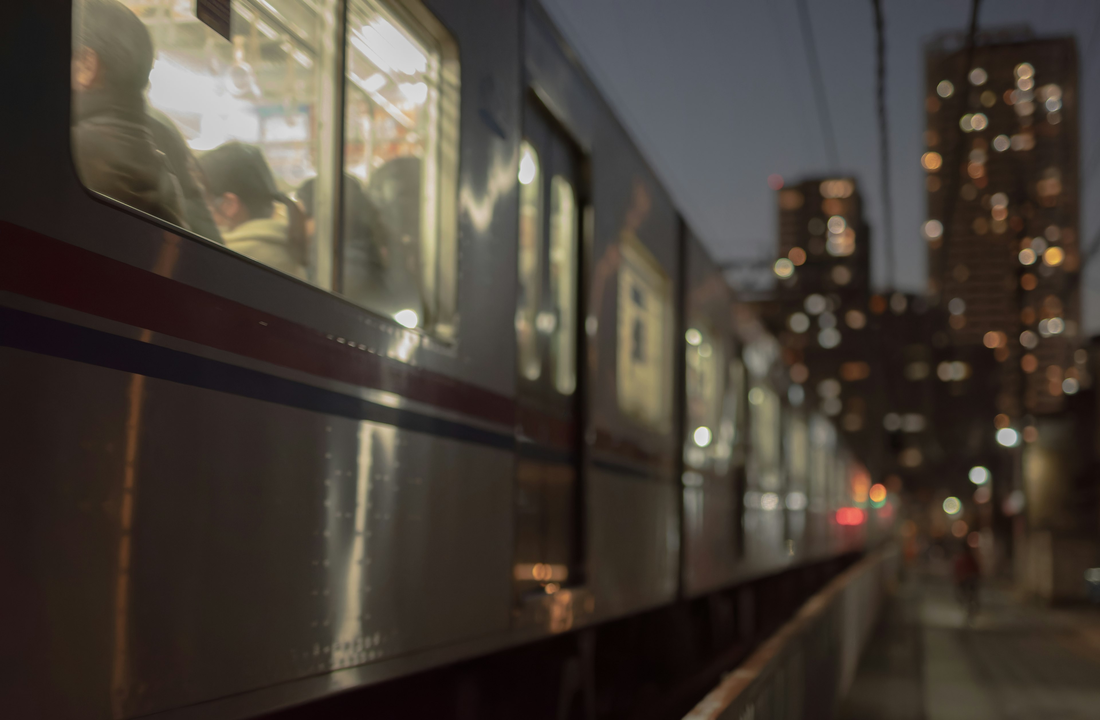 Treno fermo in una città di notte con finestre illuminate