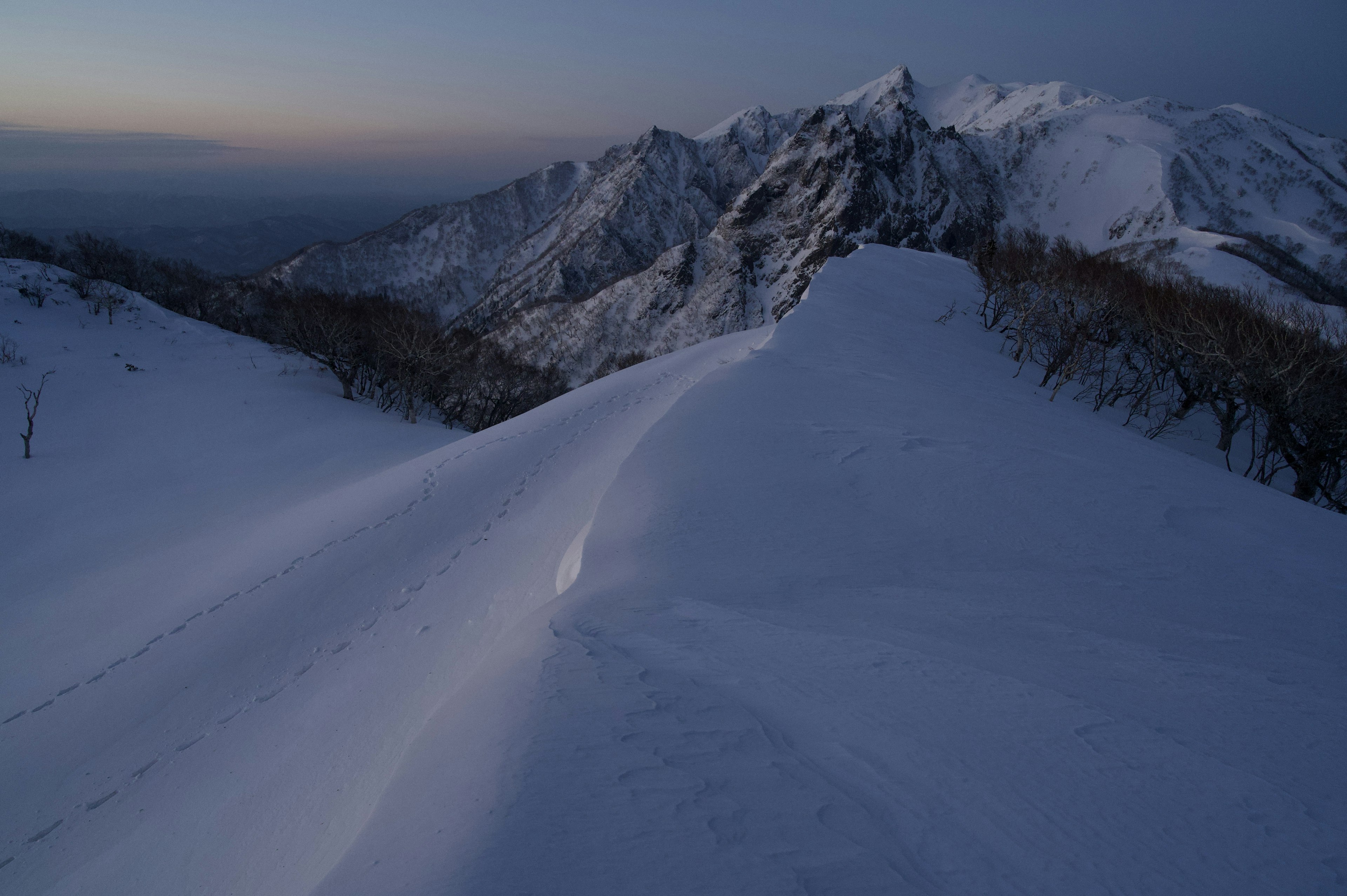 Paesaggio montano coperto di neve con cielo crepuscolare