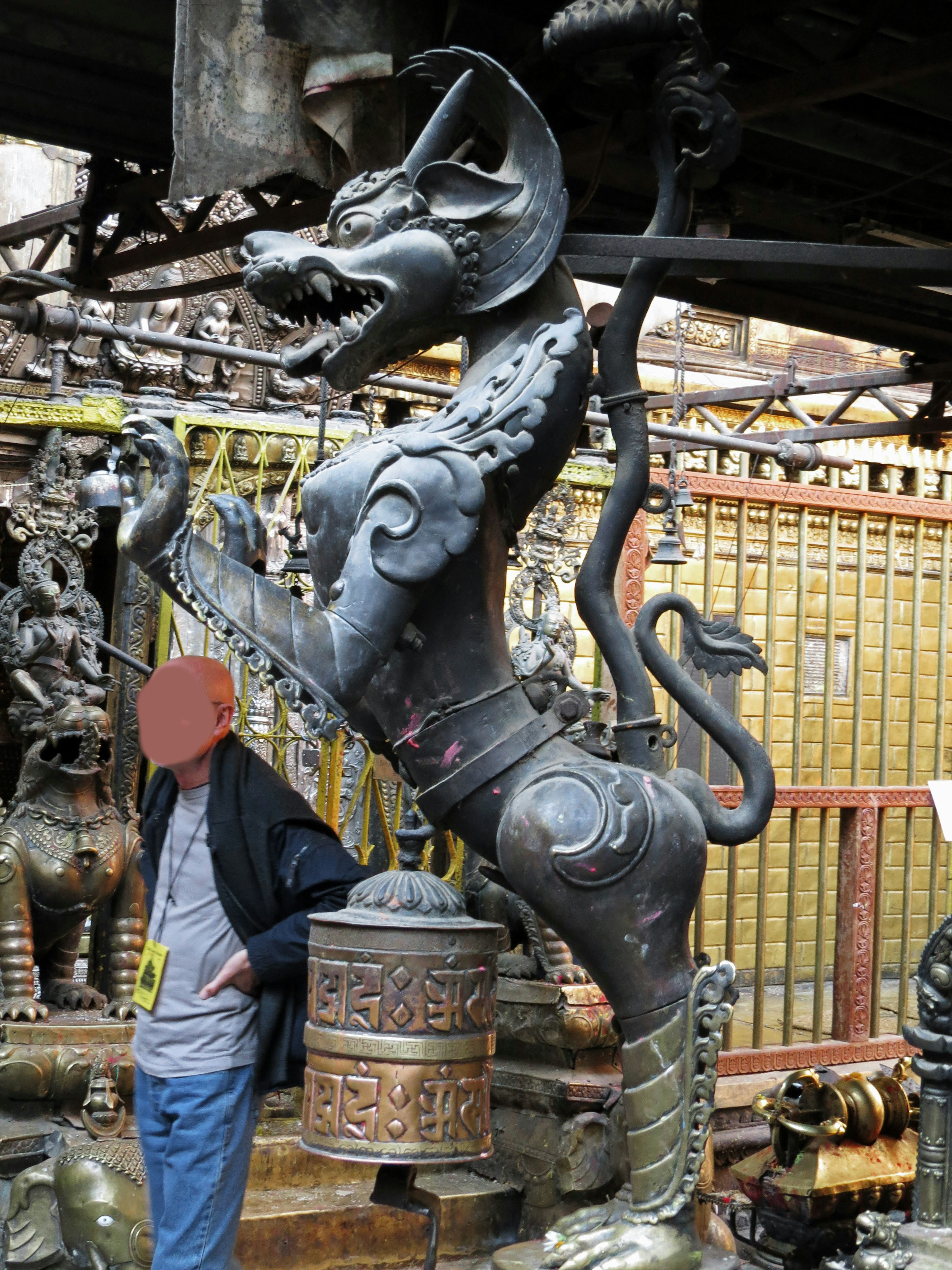 Escultura metálica única de una bestia en el fondo con una persona apoyada