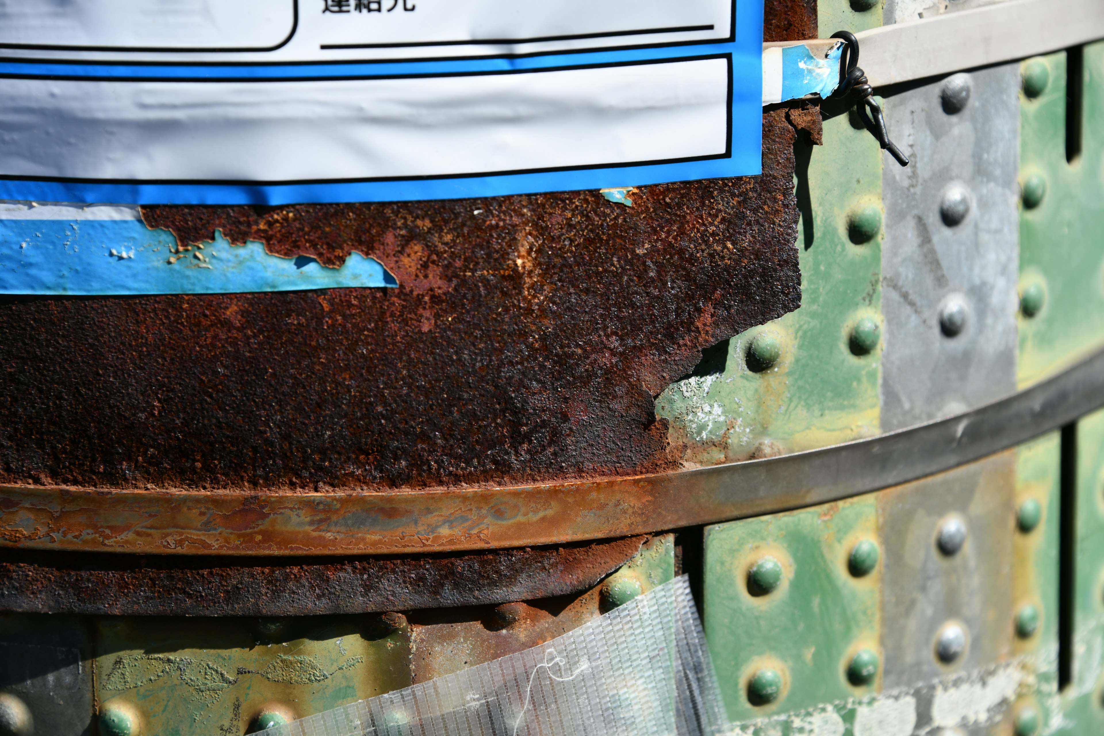 Rusty metal can with blue label and green background