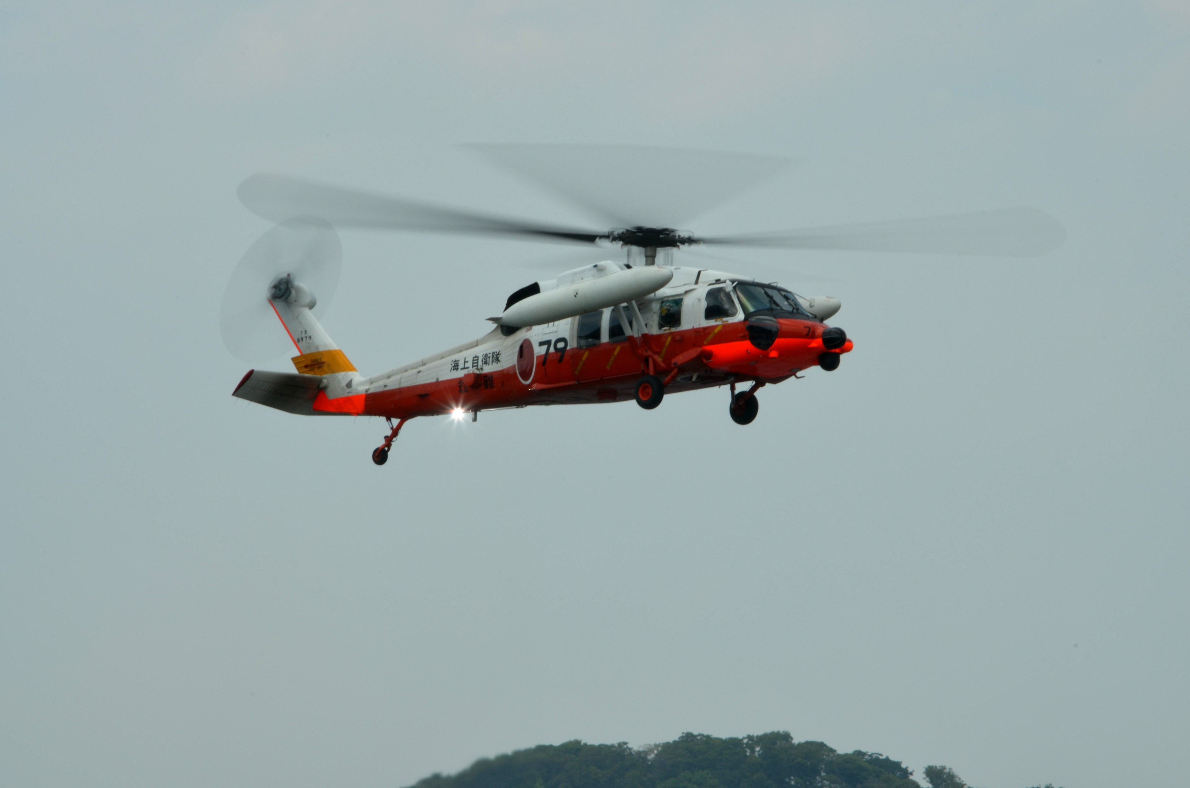 Un helicóptero rojo y blanco flotando en el cielo