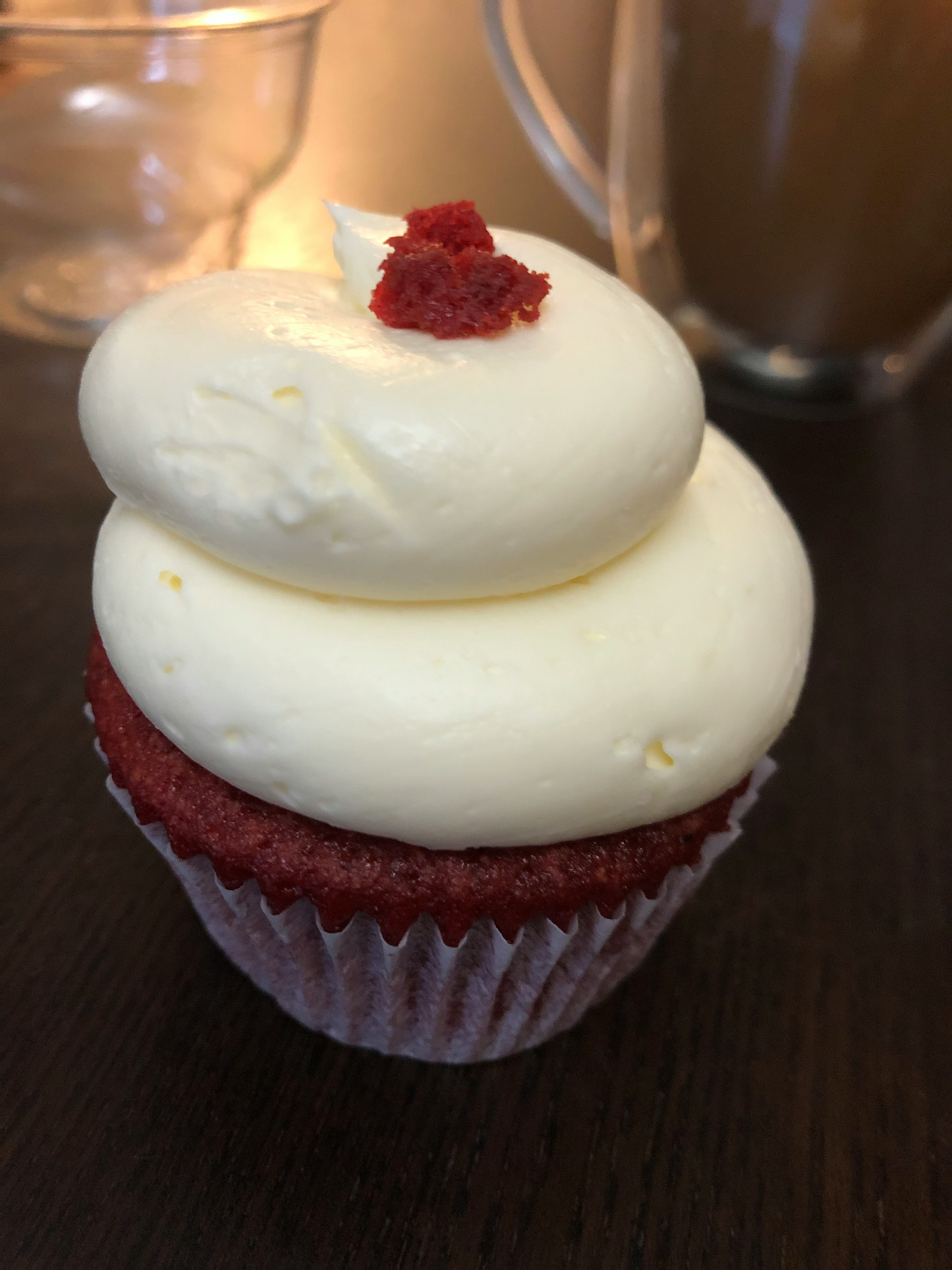 Cupcake au velours rouge surmonté d'un glaçage au fromage à la crème et saupoudré de miettes rouges