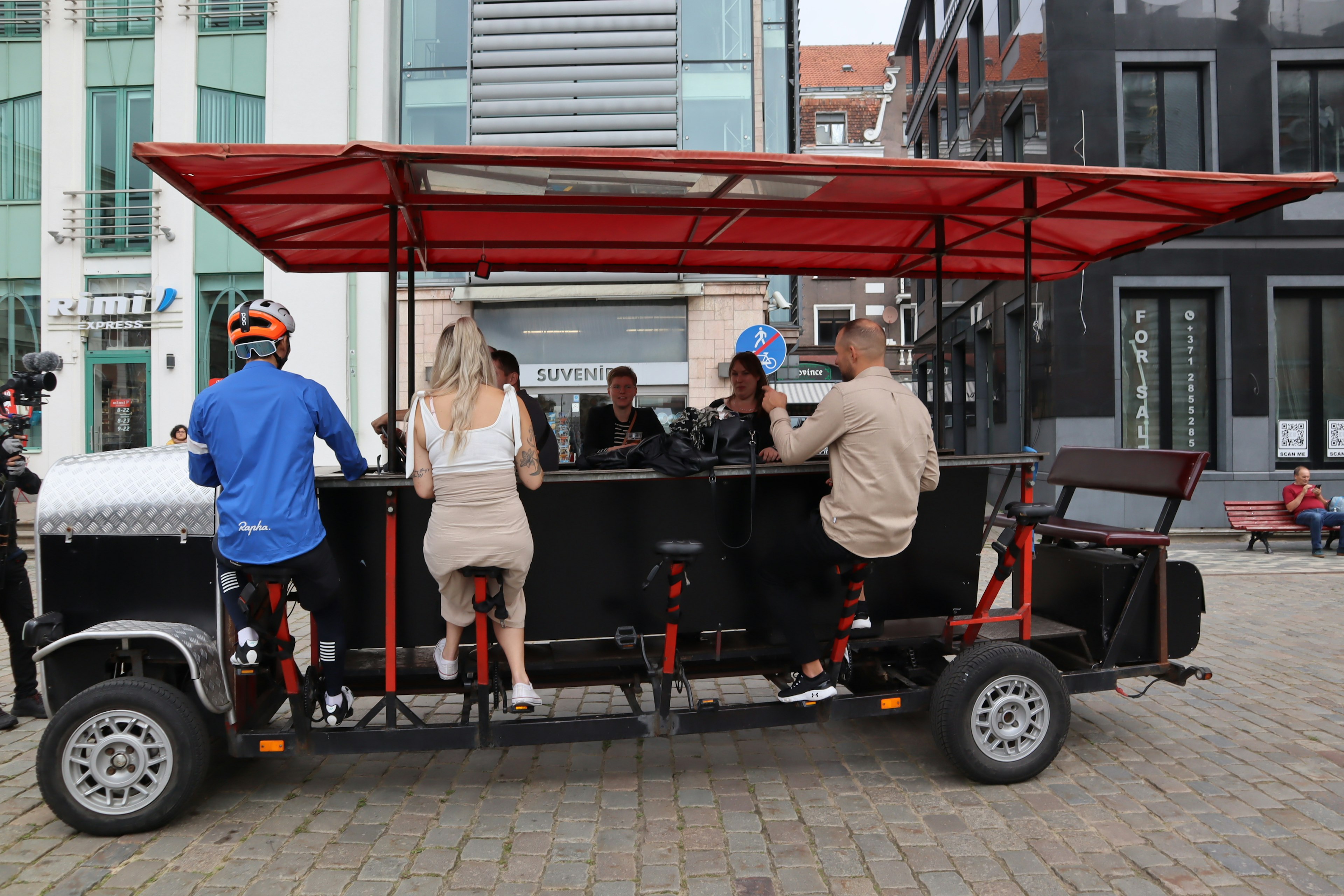 Grupo de personas disfrutando de bebidas en un bar de ciclismo con techo rojo