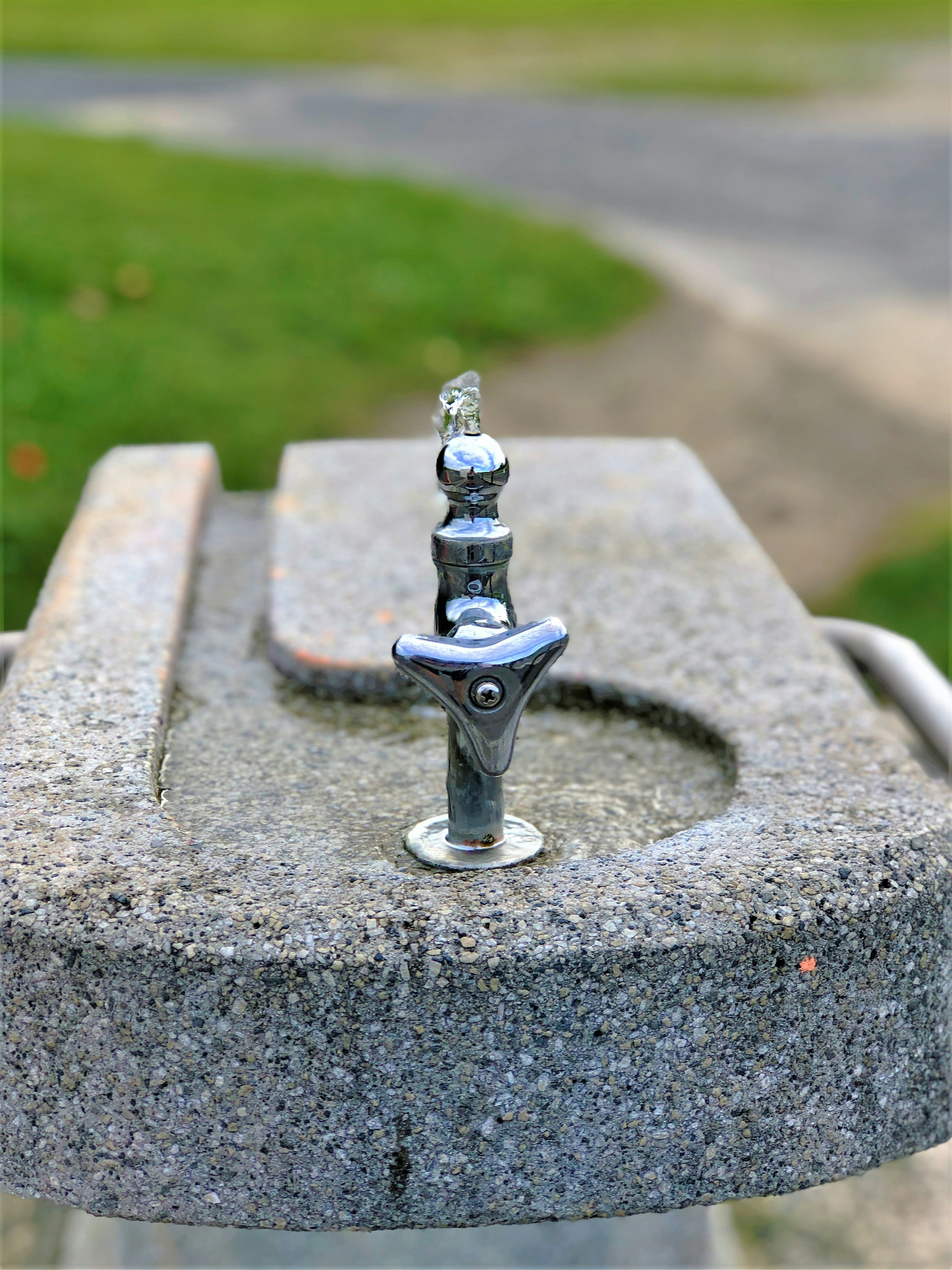 Goutte d'eau en métal sur une base en béton de fontaine à boire