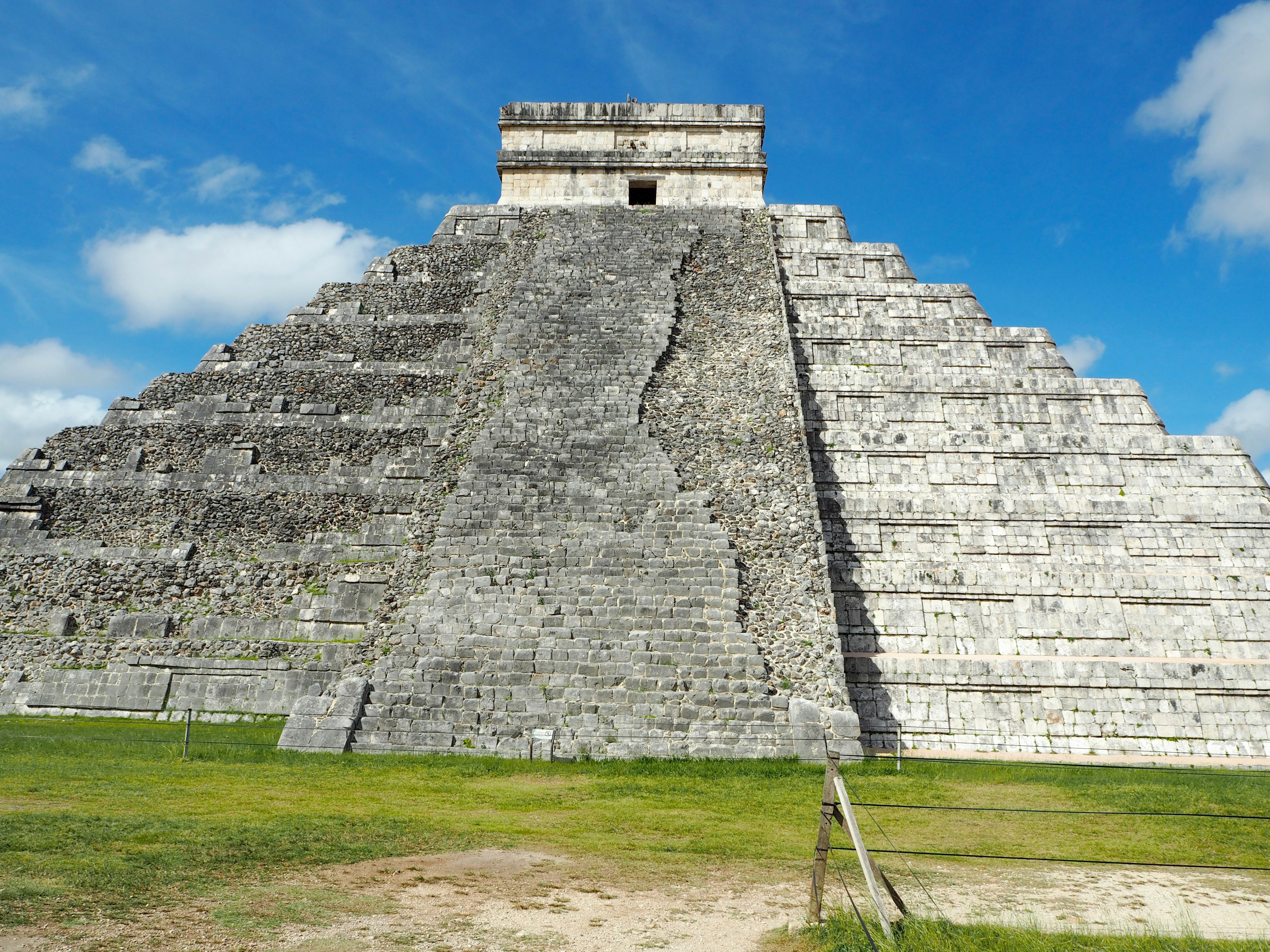 Die beeindruckende Ansicht der Pyramide von Chichen Itza vor blauem Himmel