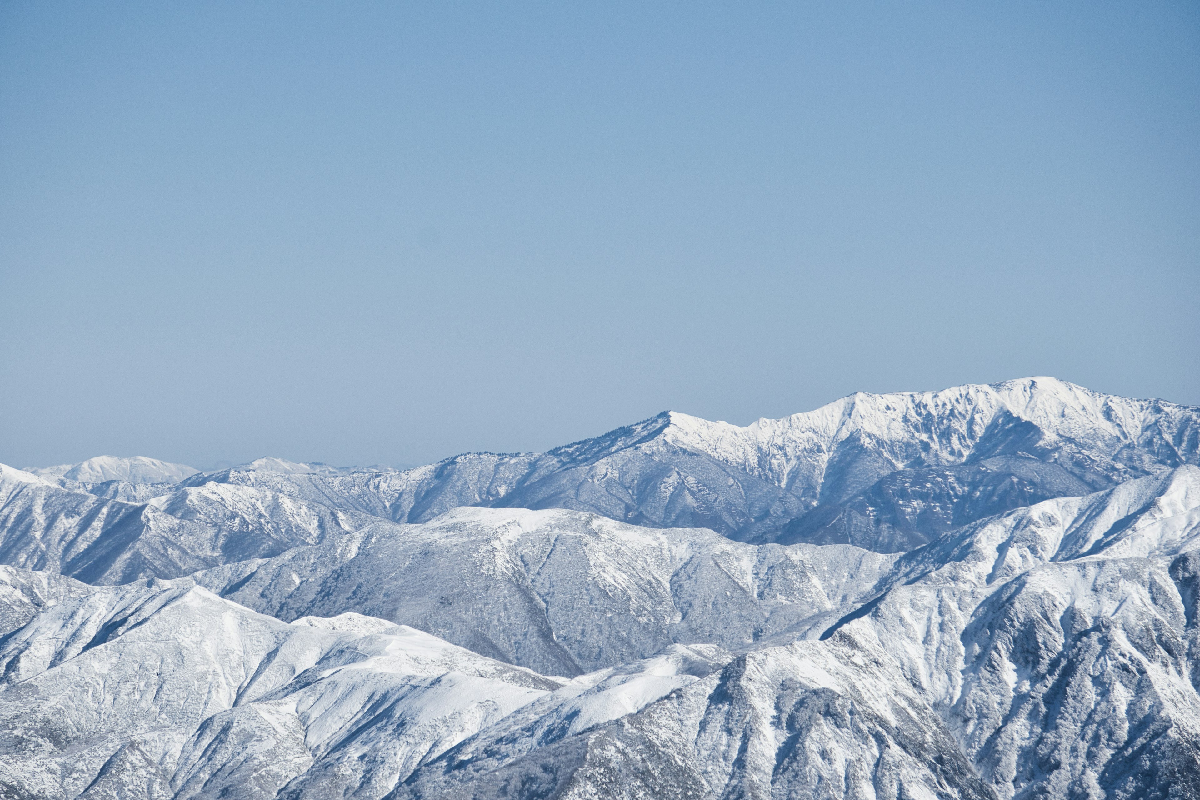 Snow-covered mountains under a clear blue sky