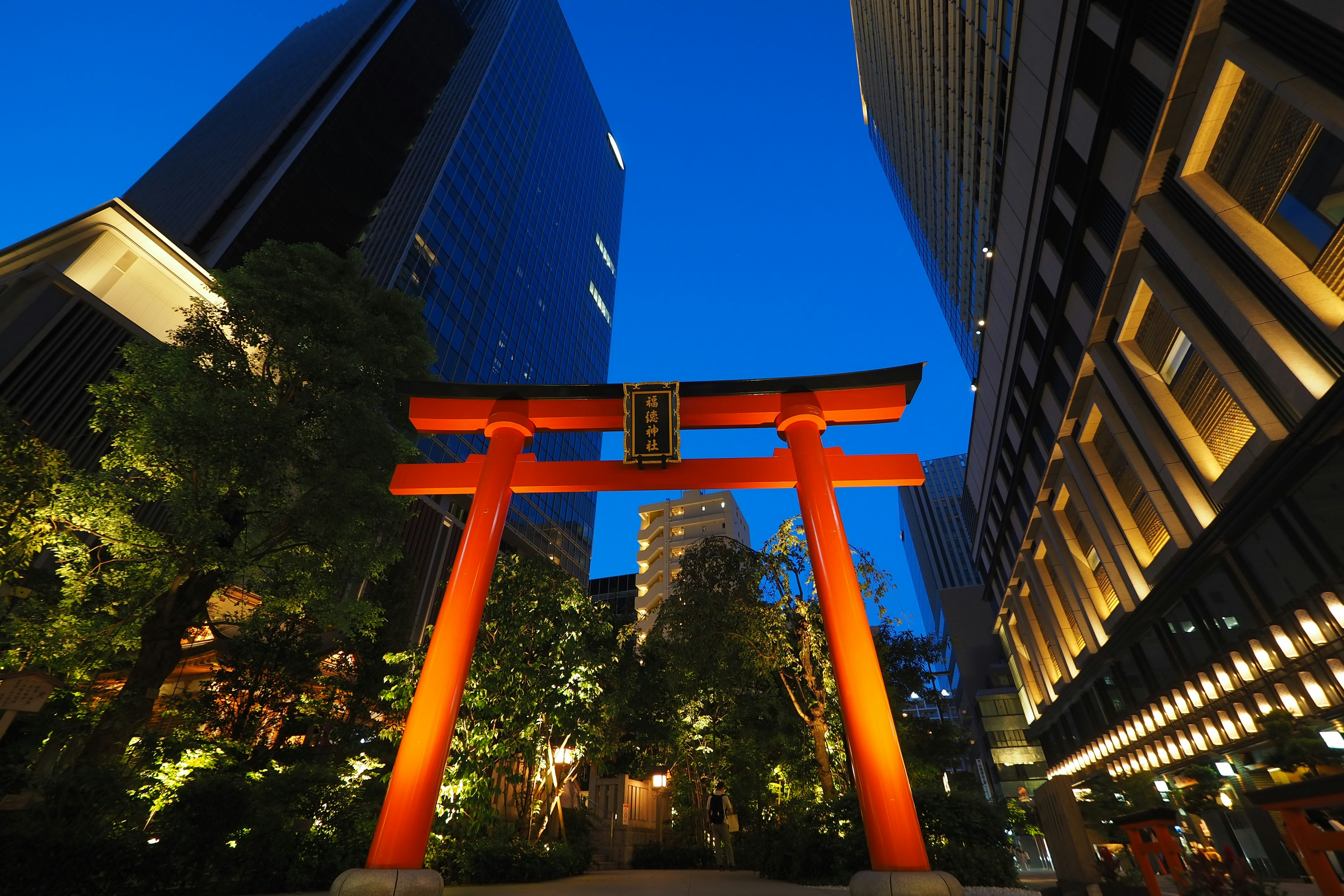 Rote Torii-Gate bei Nacht umgeben von modernen Gebäuden