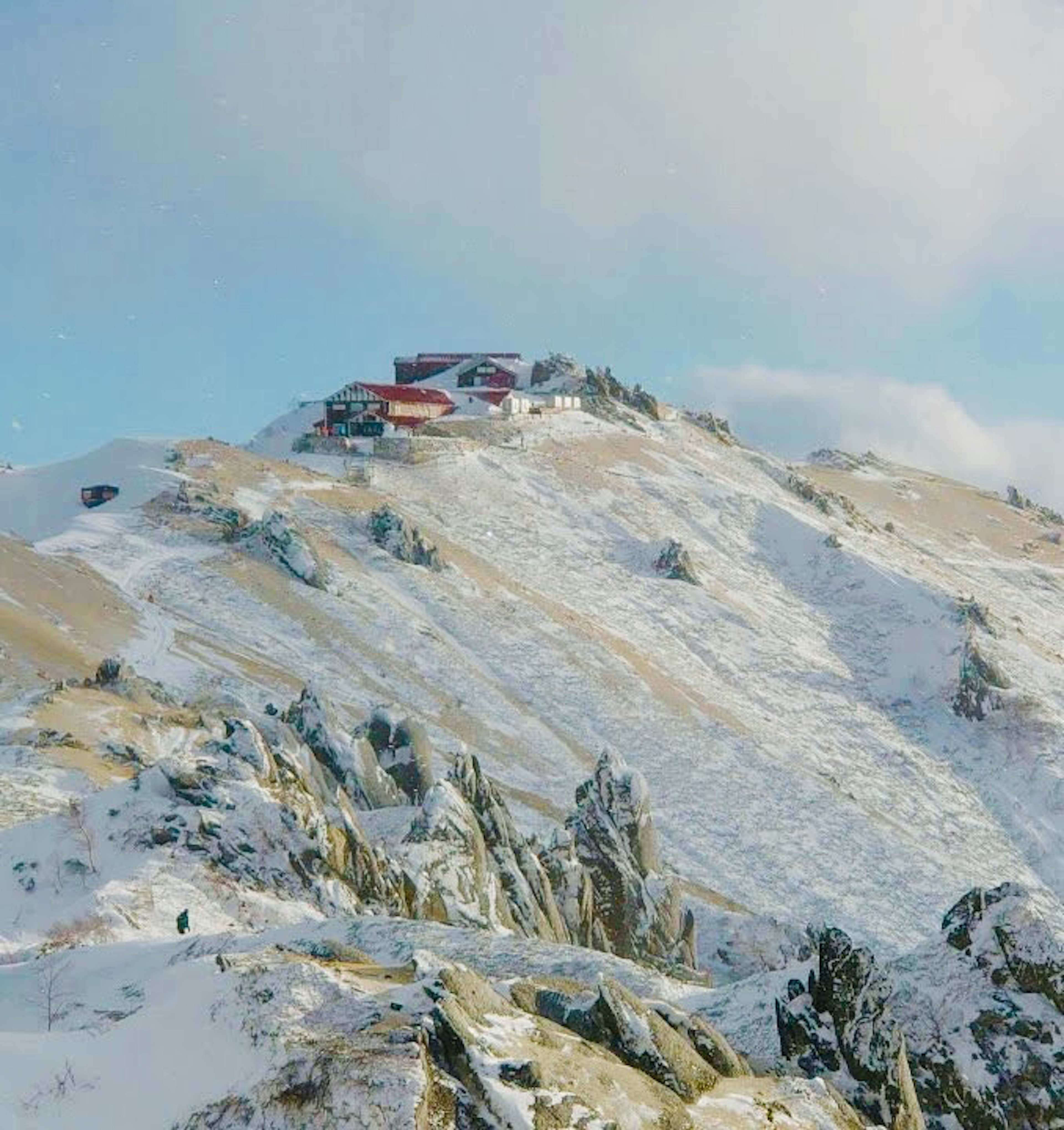 雪に覆われた山の頂上にある小屋の風景