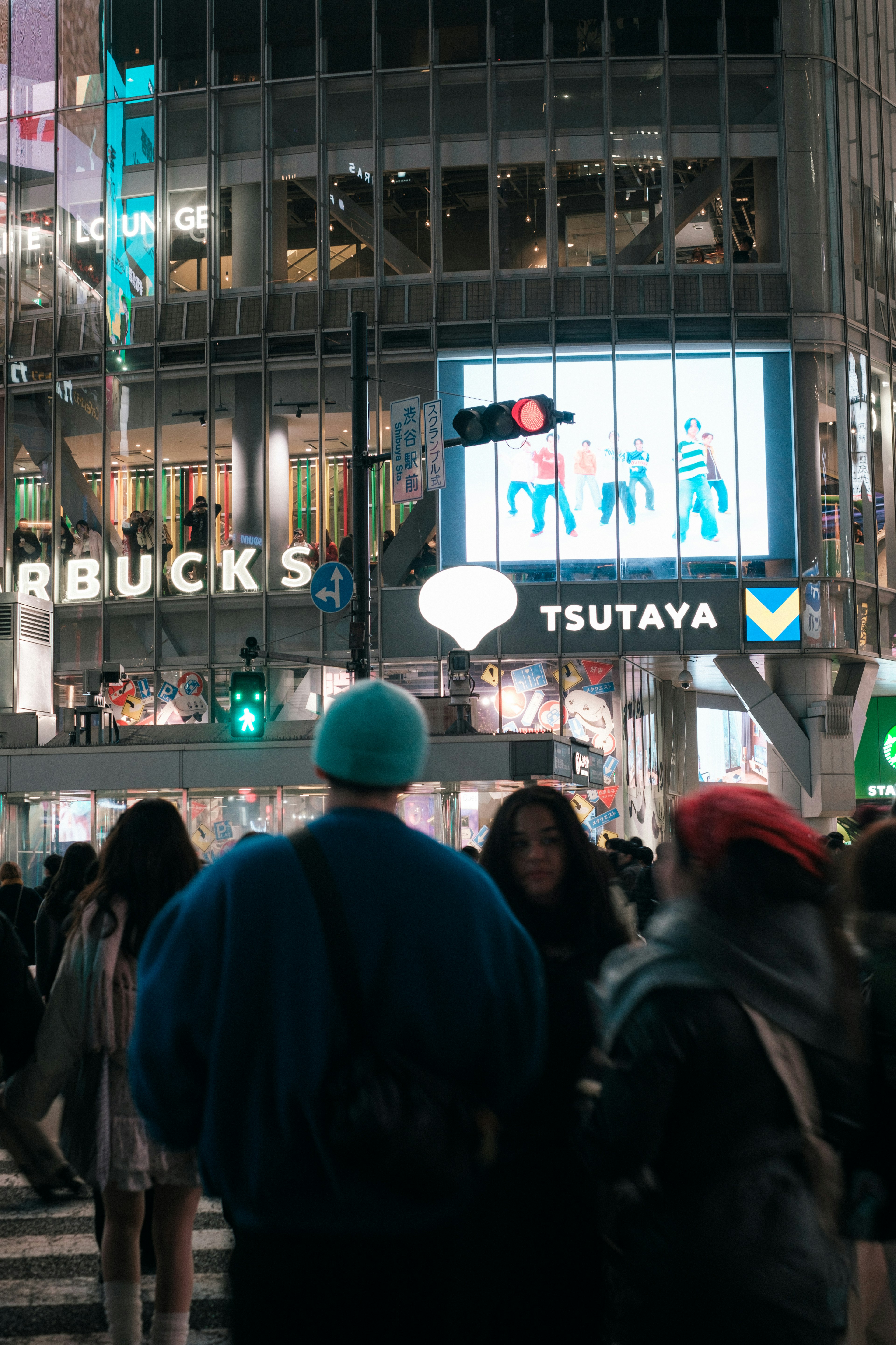 Kerumunan di Shibuya dengan tanda Tsutaya dan Starbucks di latar belakang