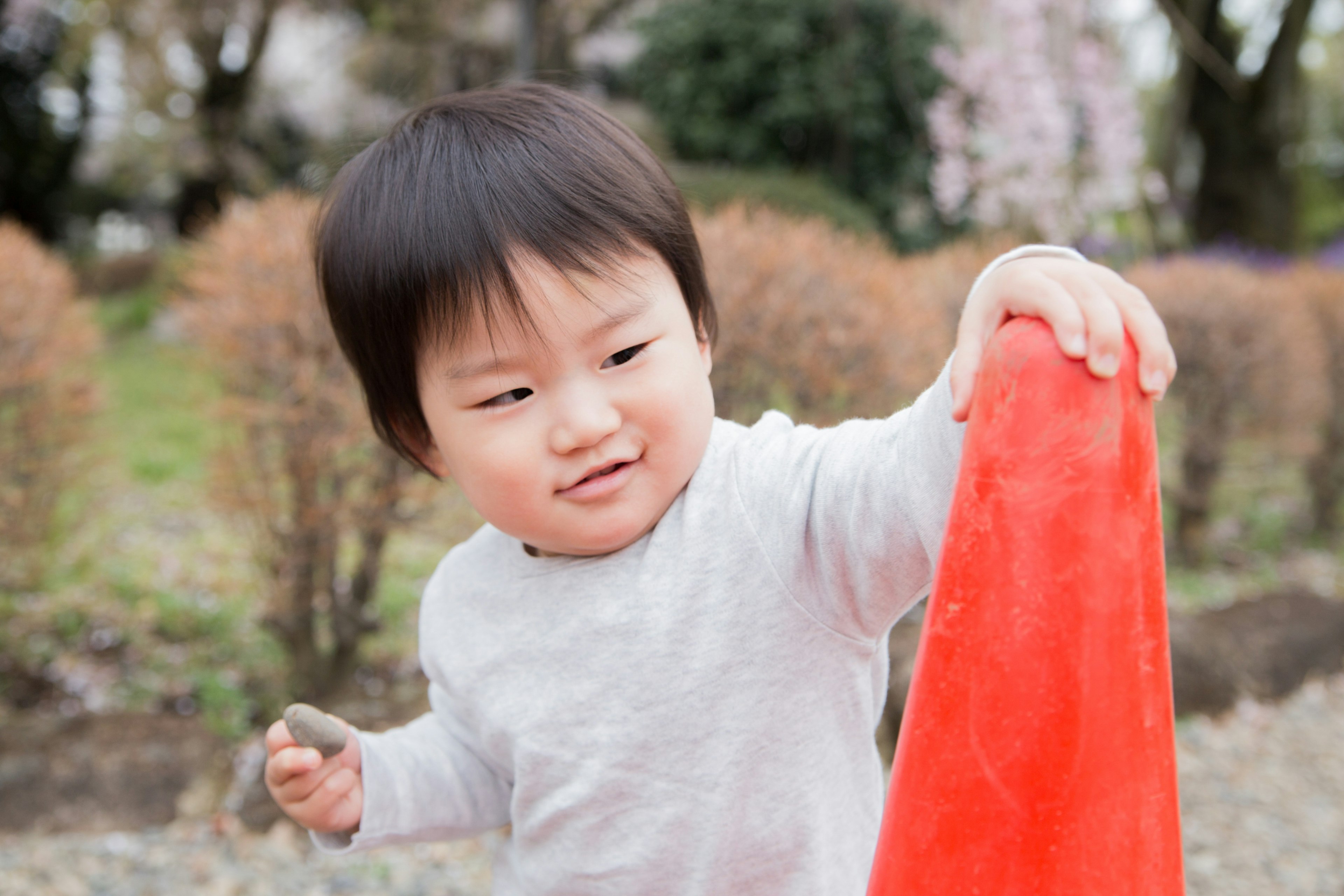 公園で赤いオブジェを持つ子供の笑顔