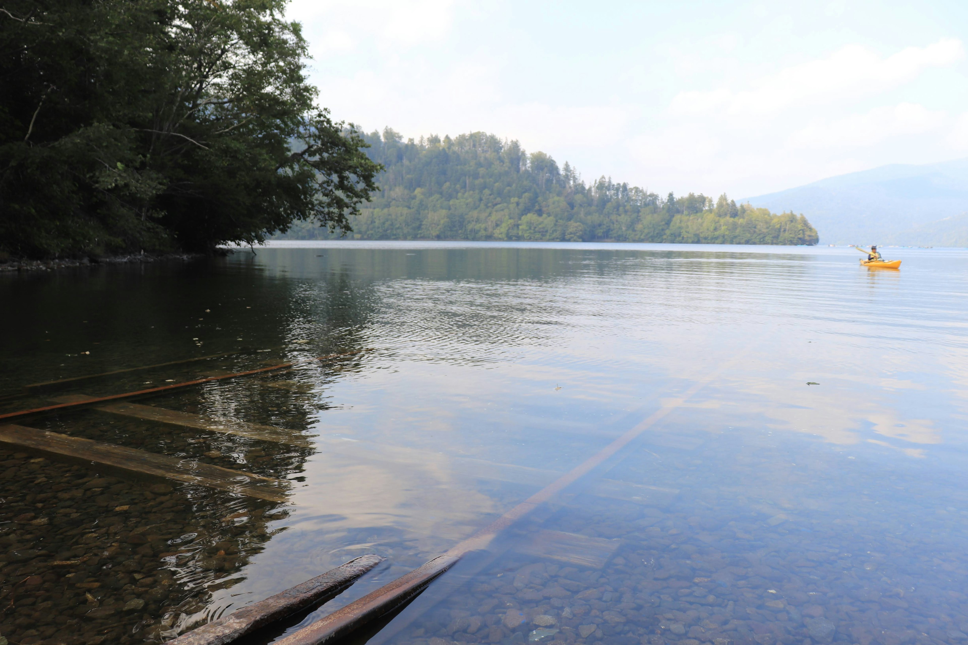 Vue sereine du lac avec un kayak au loin