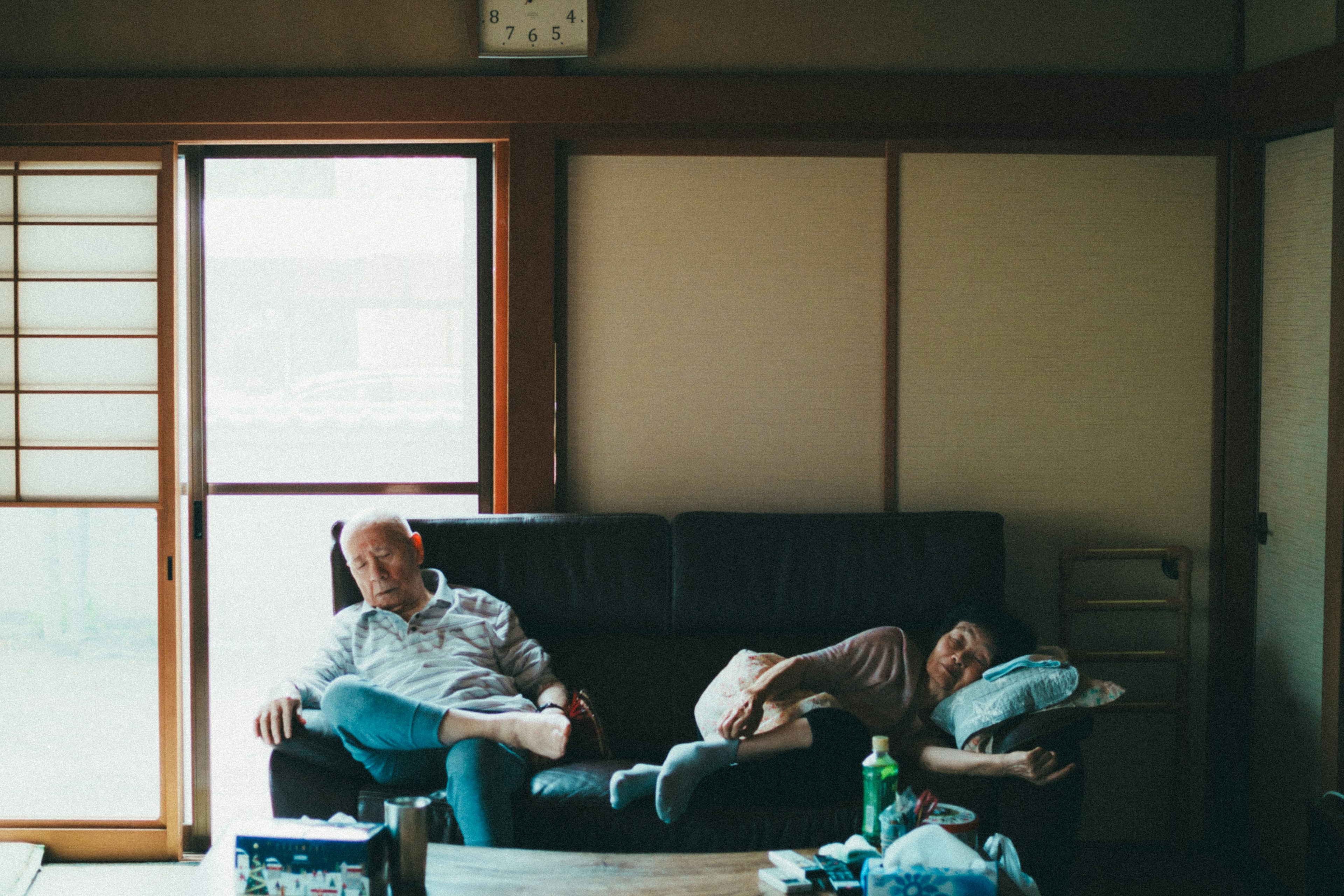 Two men relaxing on a sofa in a living room