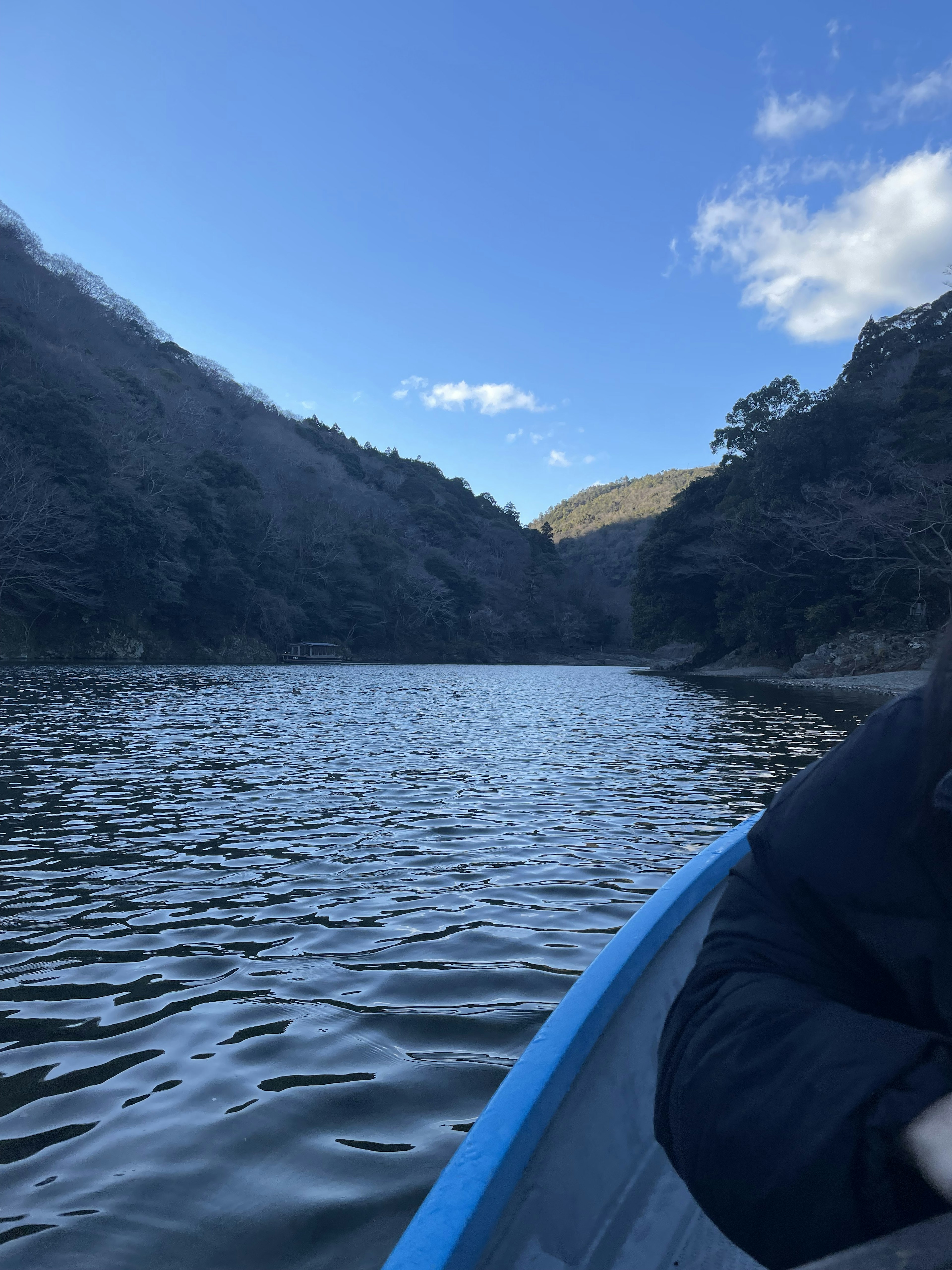 A serene lake surrounded by mountains under a blue sky