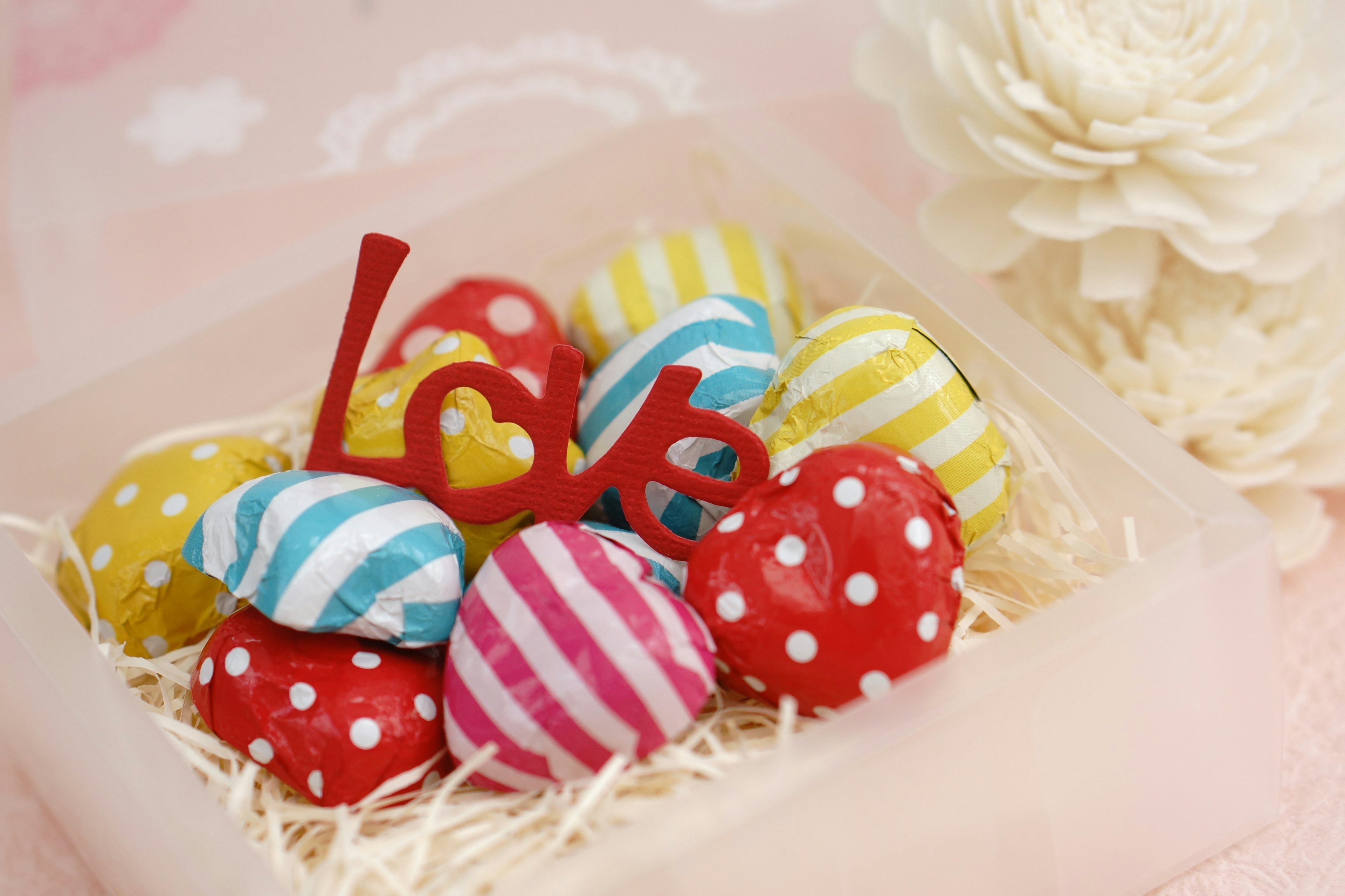 Colorful heart-shaped decorative stones with a red 'love' text in a cute arrangement