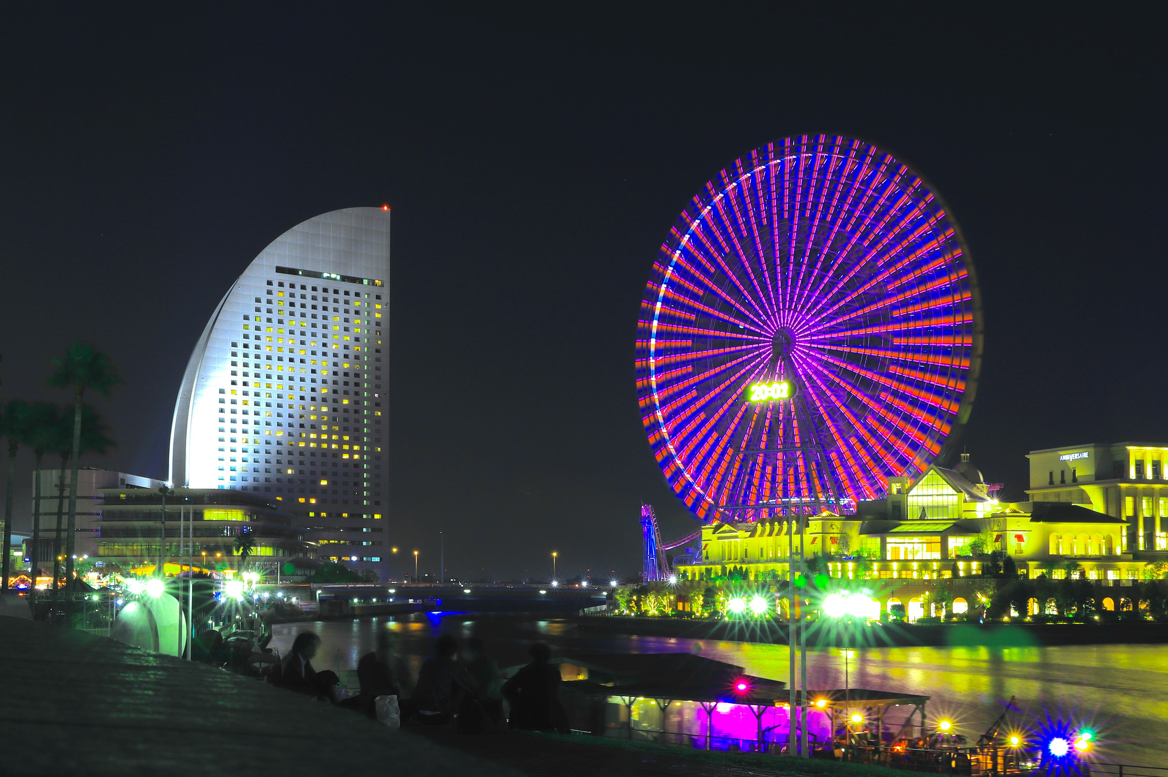 Vista notturna di Yokohama con una ruota panoramica colorata e edifici moderni