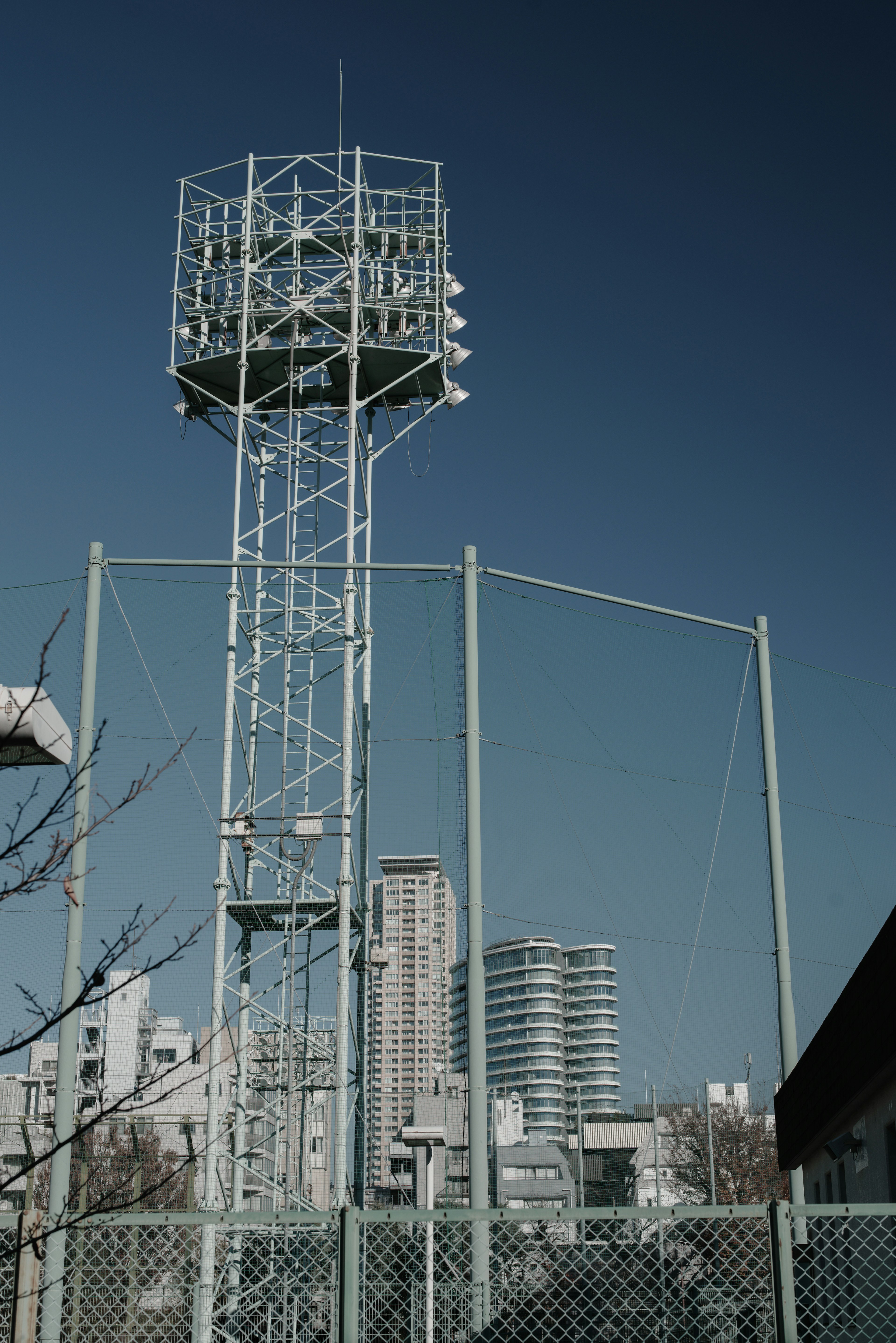 Alto torre di comunicazione circondata da edifici urbani