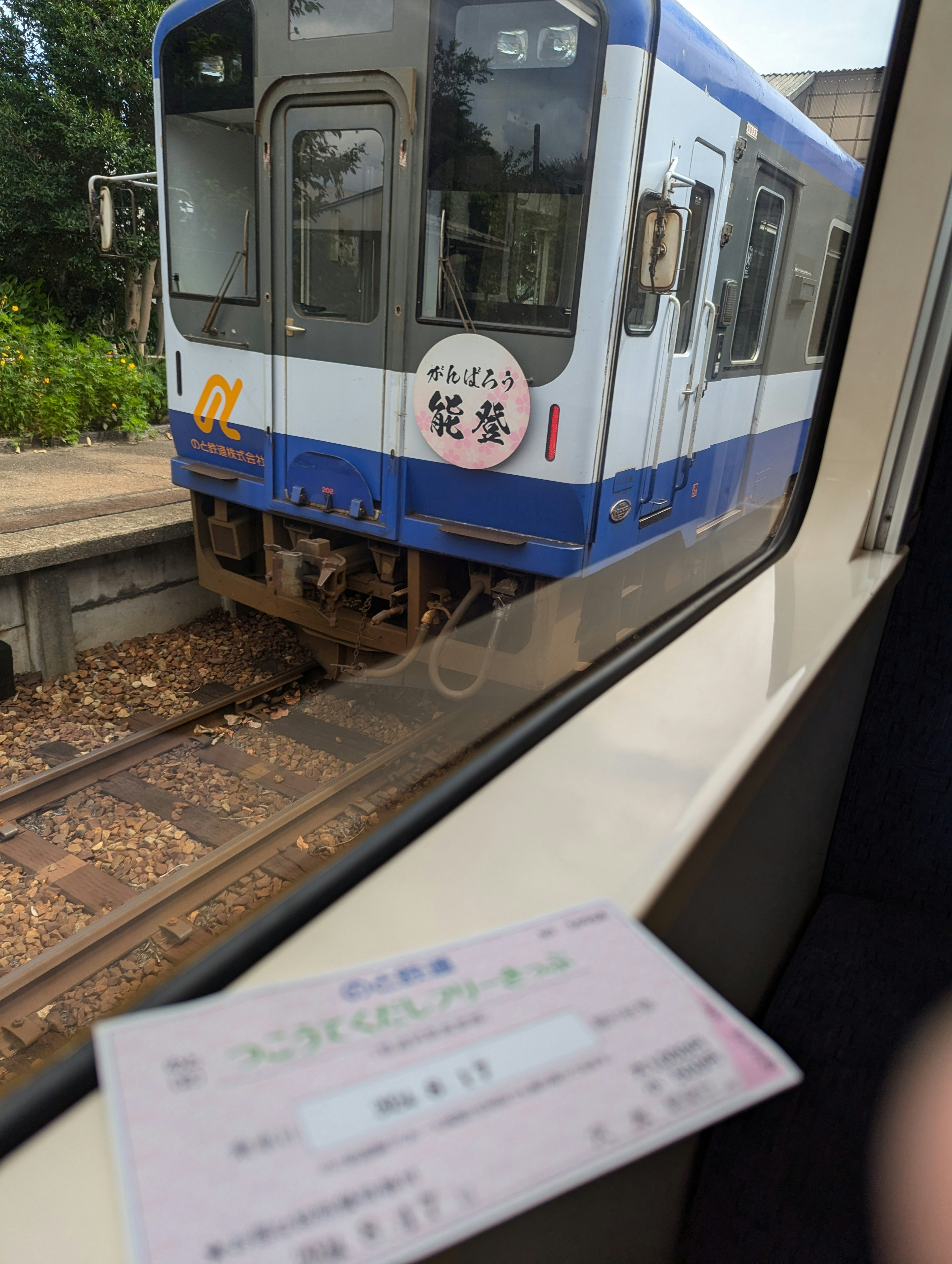 Vue d'un train bleu depuis la fenêtre avec un billet