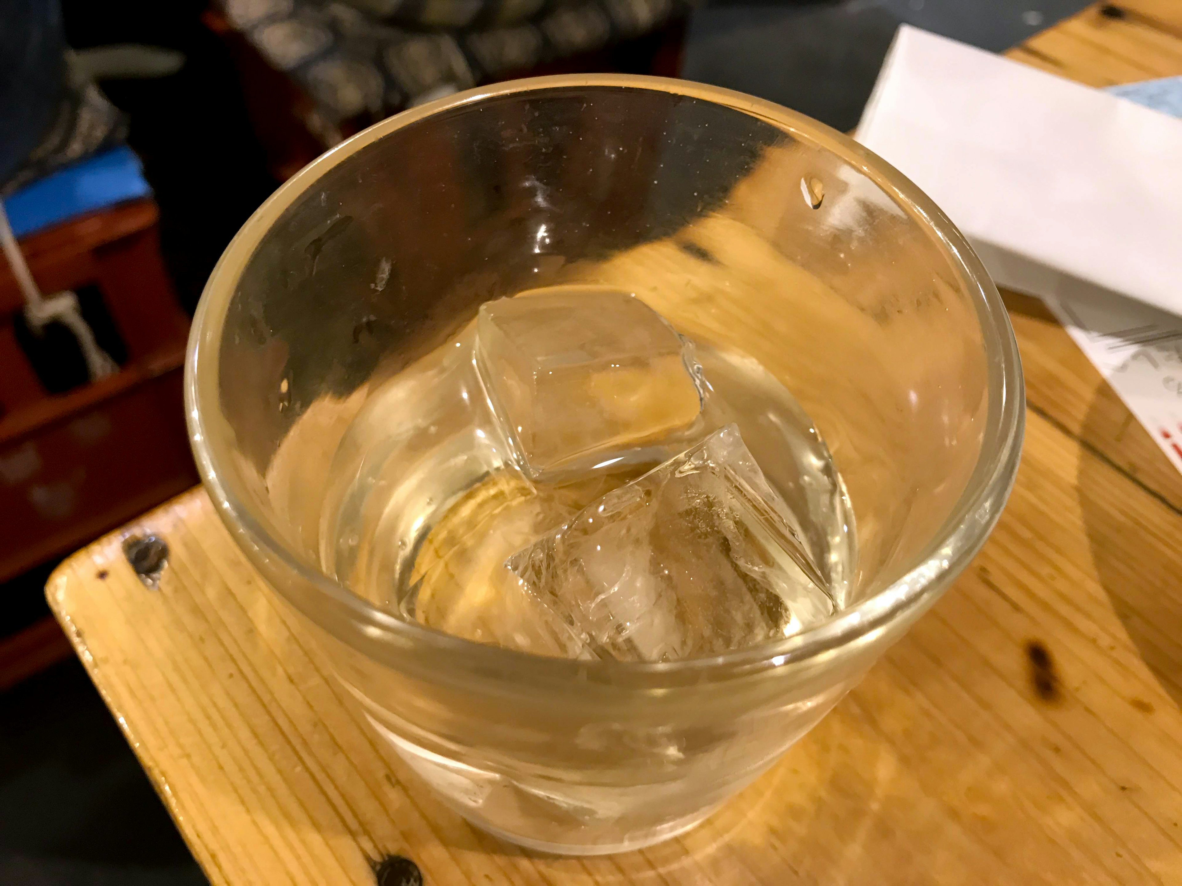 Un verre transparent avec des glaçons et une boisson froide