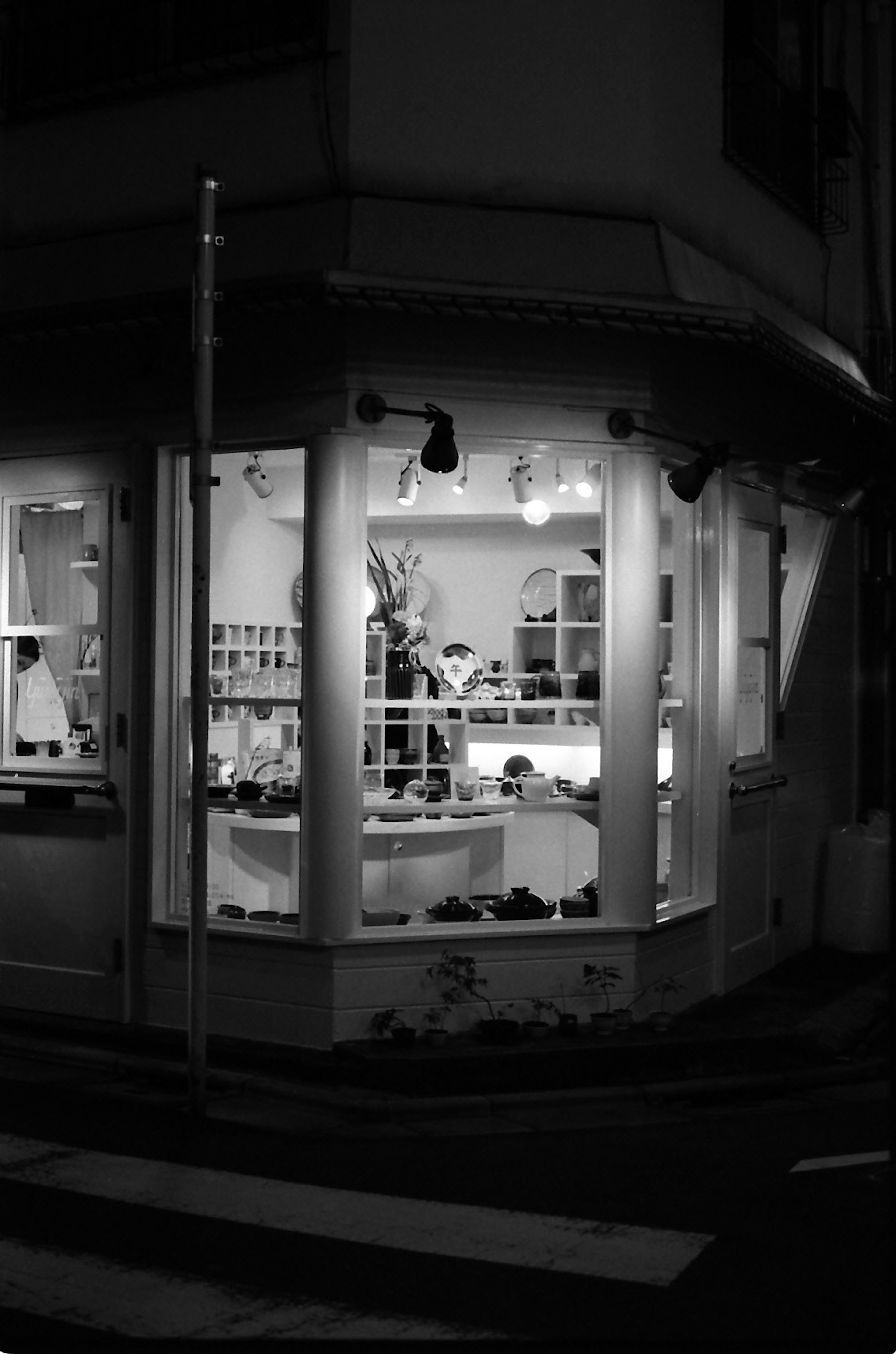 Black and white image of a store front with visible interior