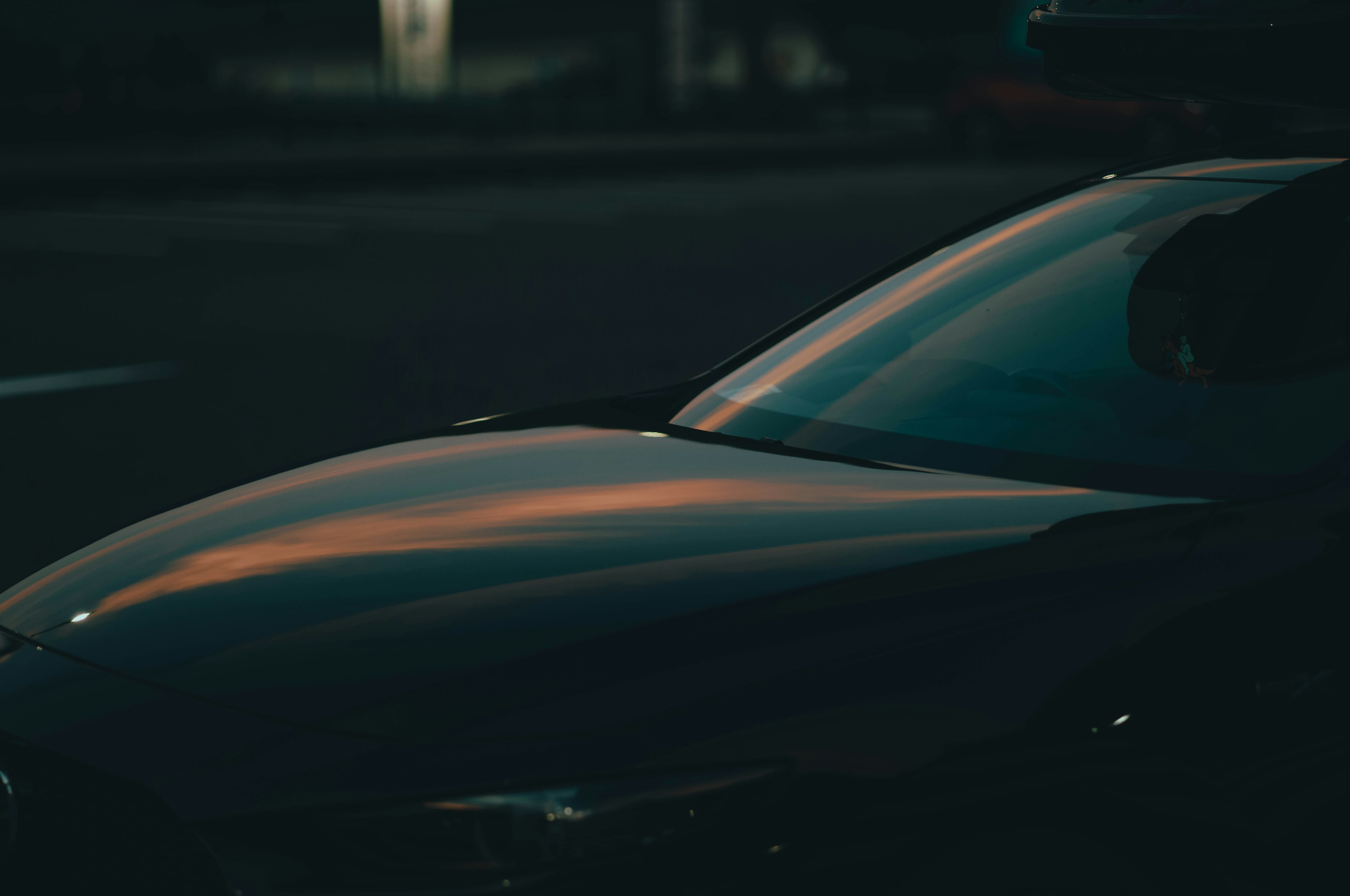 Reflejo y textura suave de la carrocería de un coche sobre un fondo oscuro