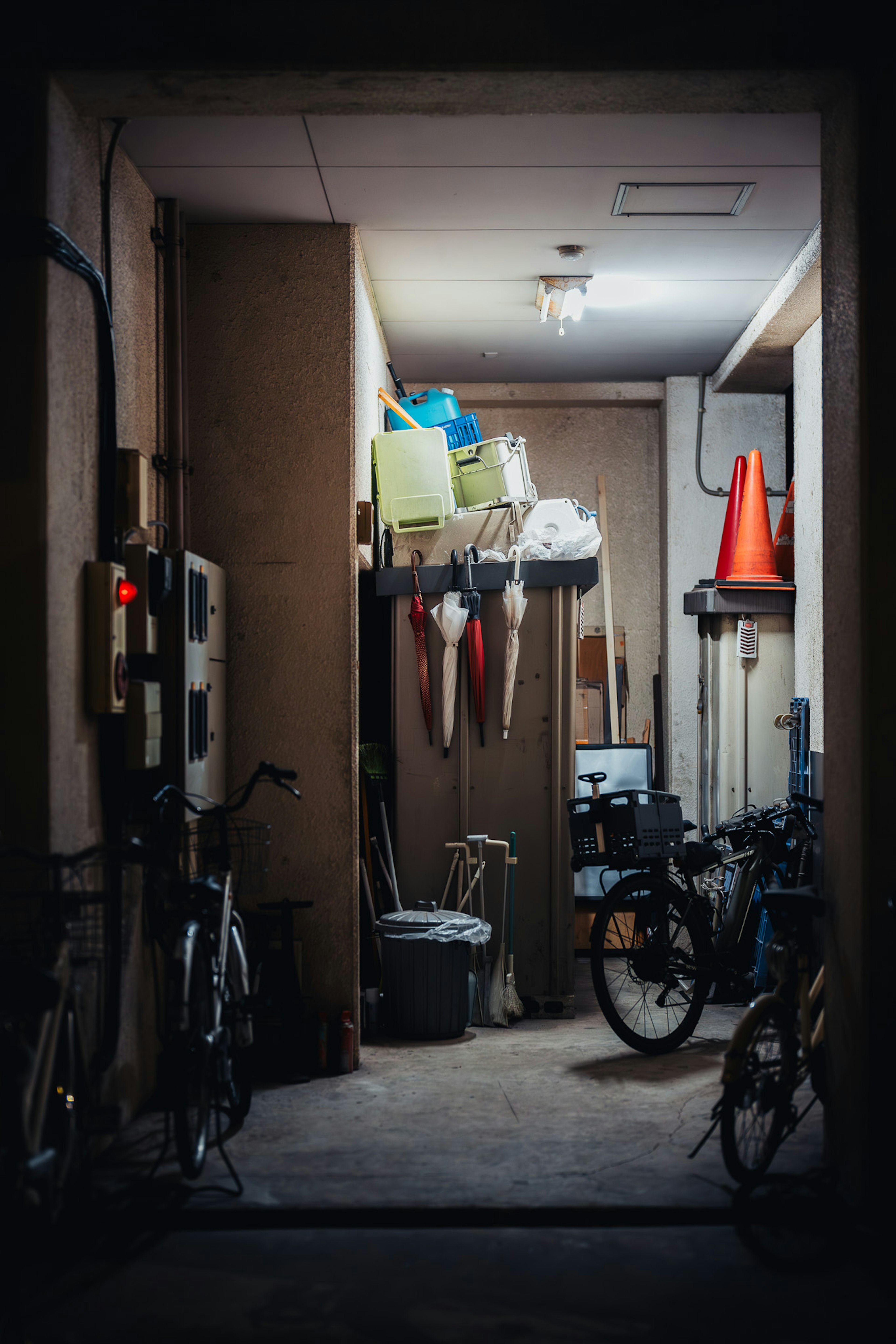 Corridoio poco illuminato con biciclette e attrezzi riposti