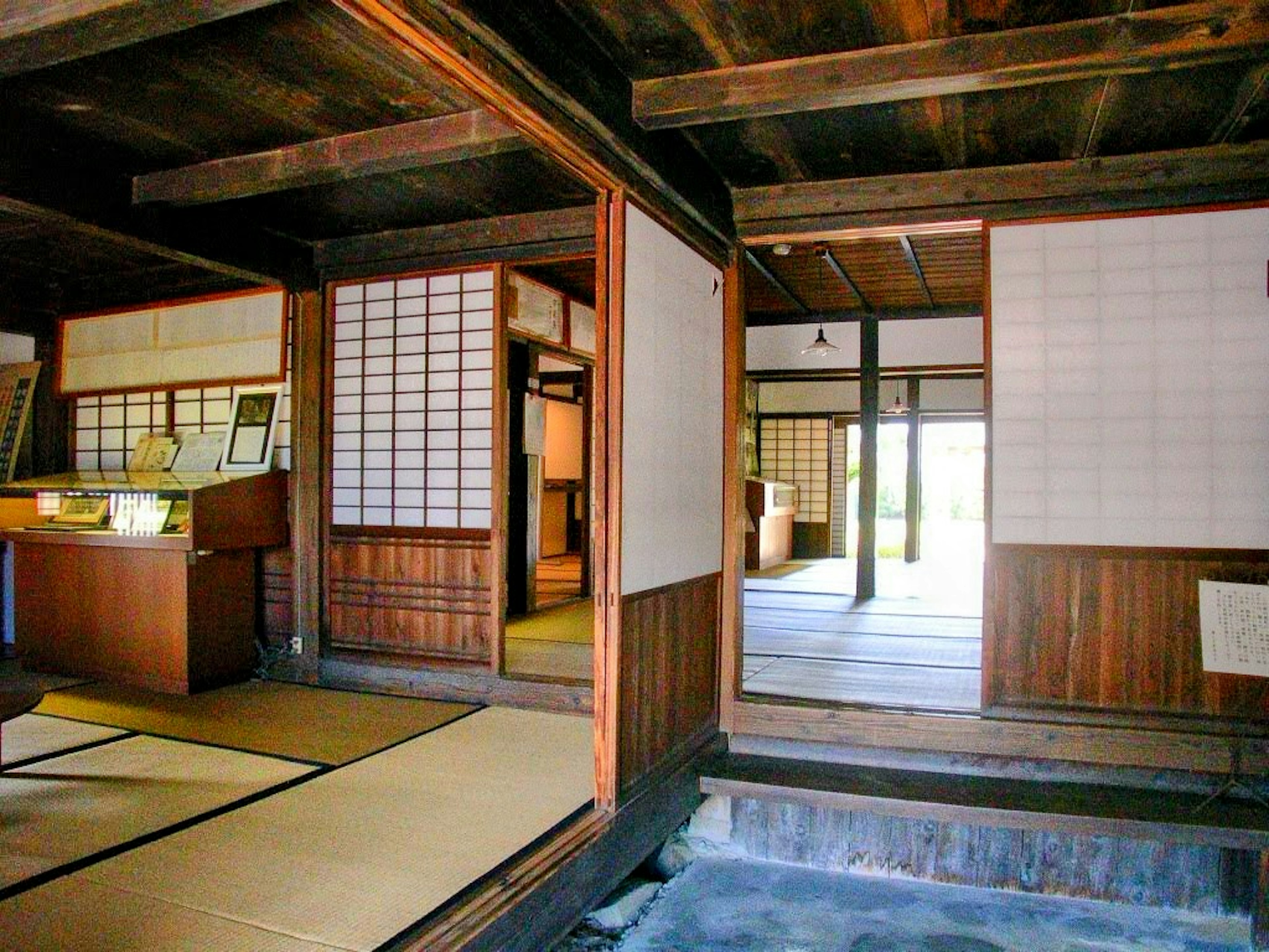 Interior of a traditional Japanese room featuring wooden beams and tatami flooring