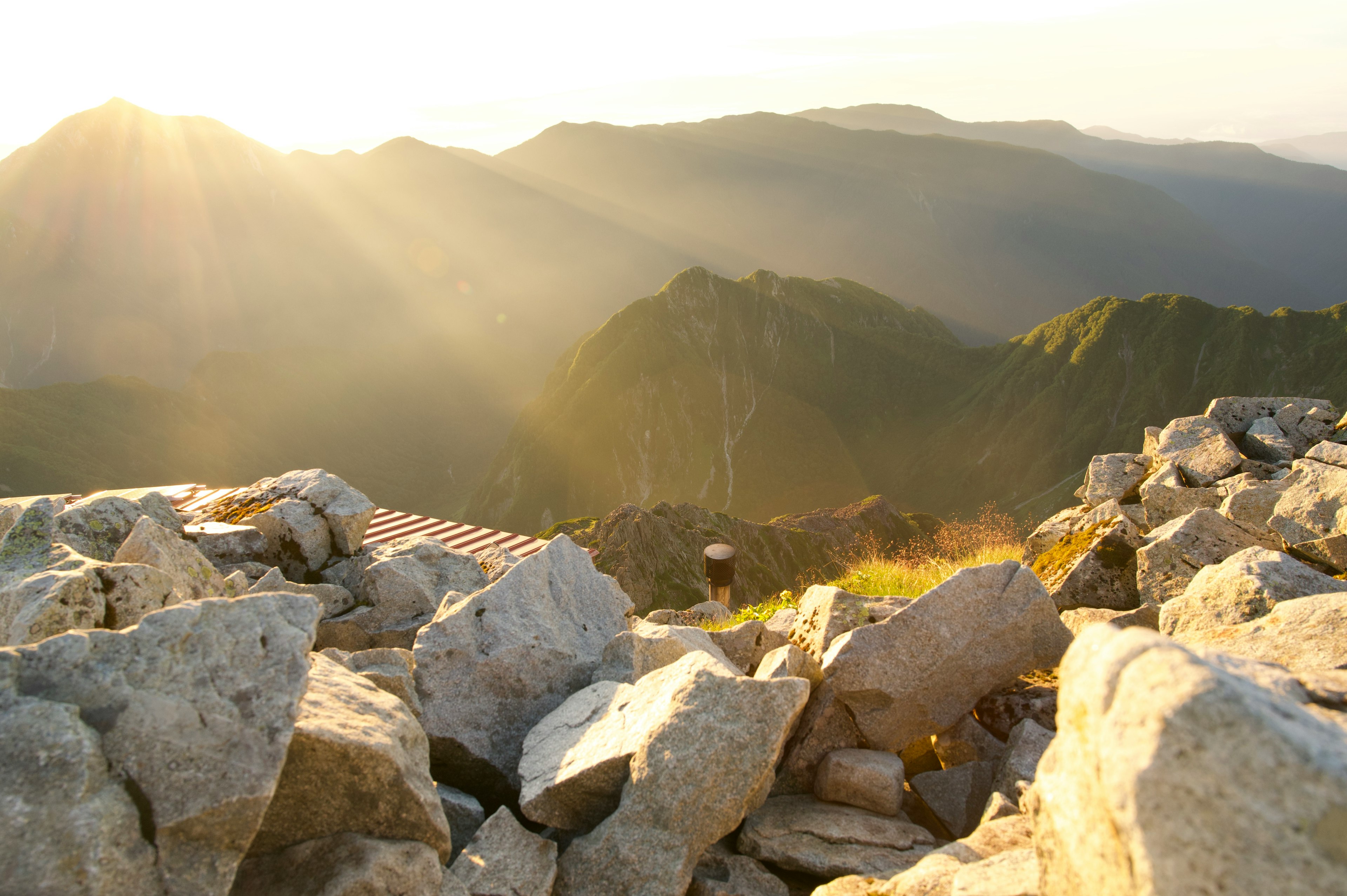 Berglandschaft mit Sonnenlicht, das auf Felsen und grasbewachsene Flächen scheint