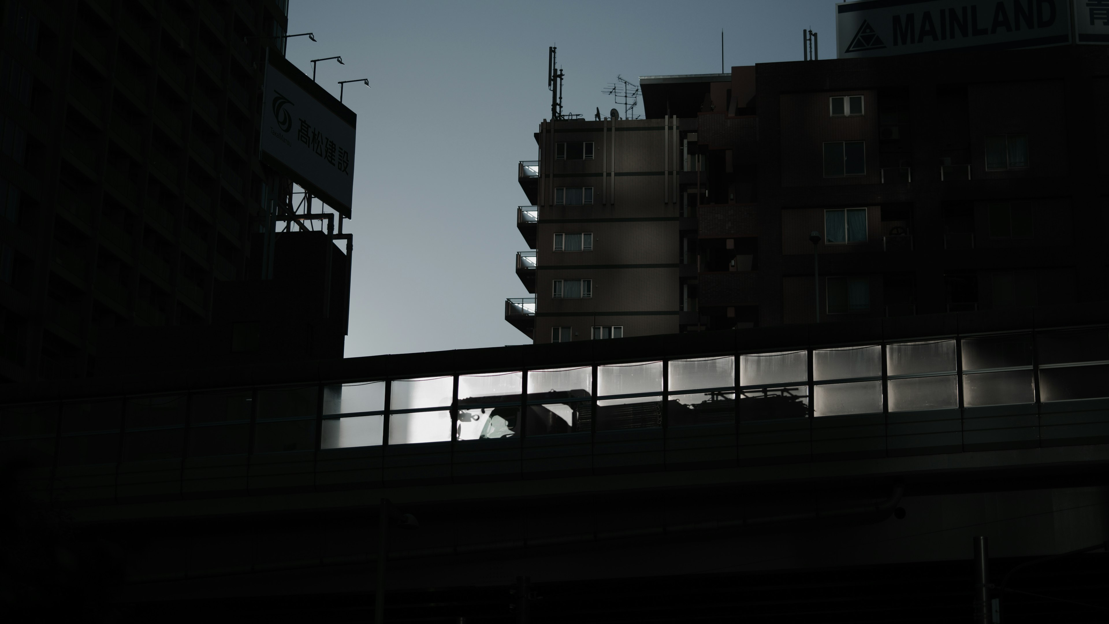 高層ビルのシルエットと橋の影が映る都市の風景