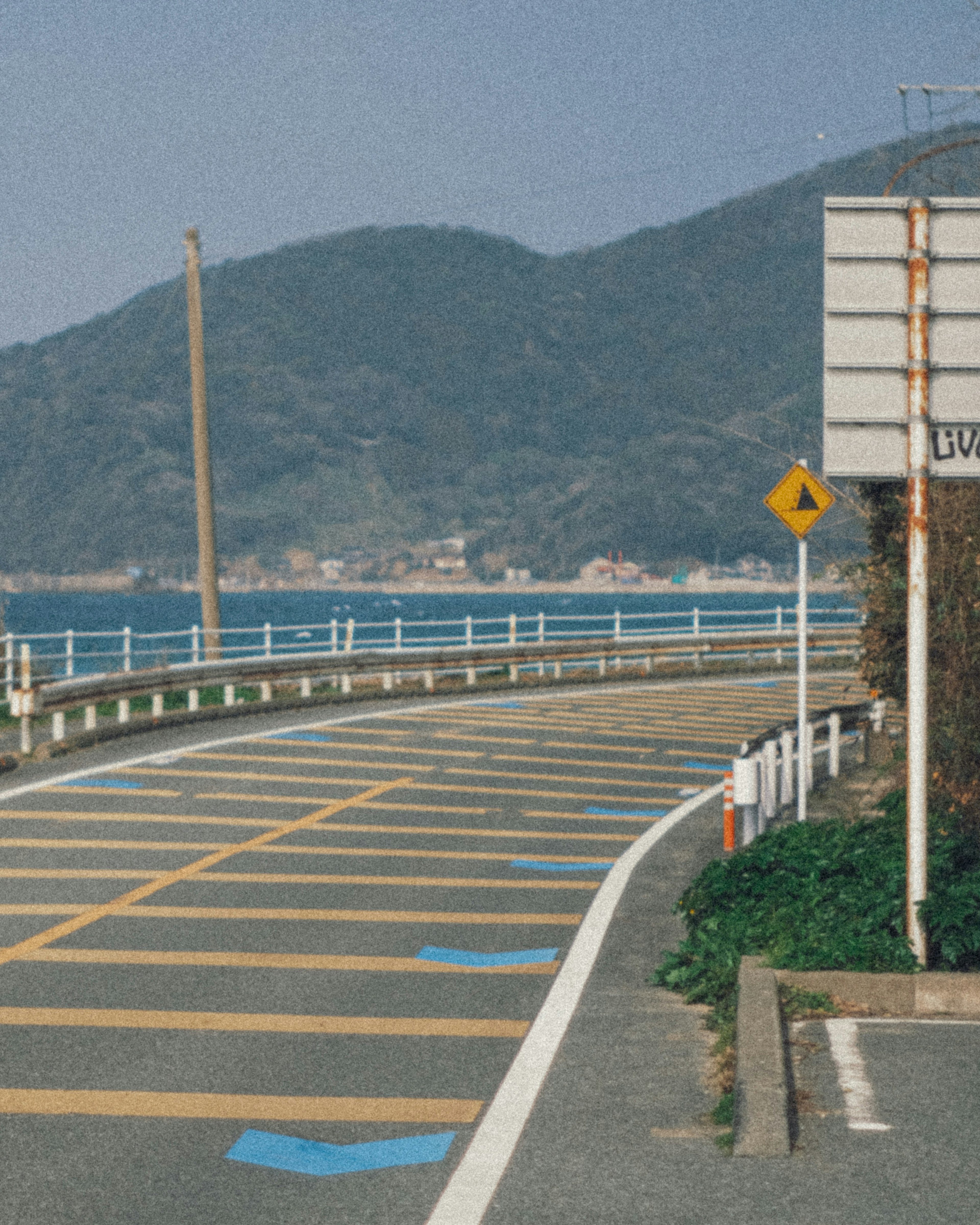 青い海と山々を背景にした湾岸道路のカーブ