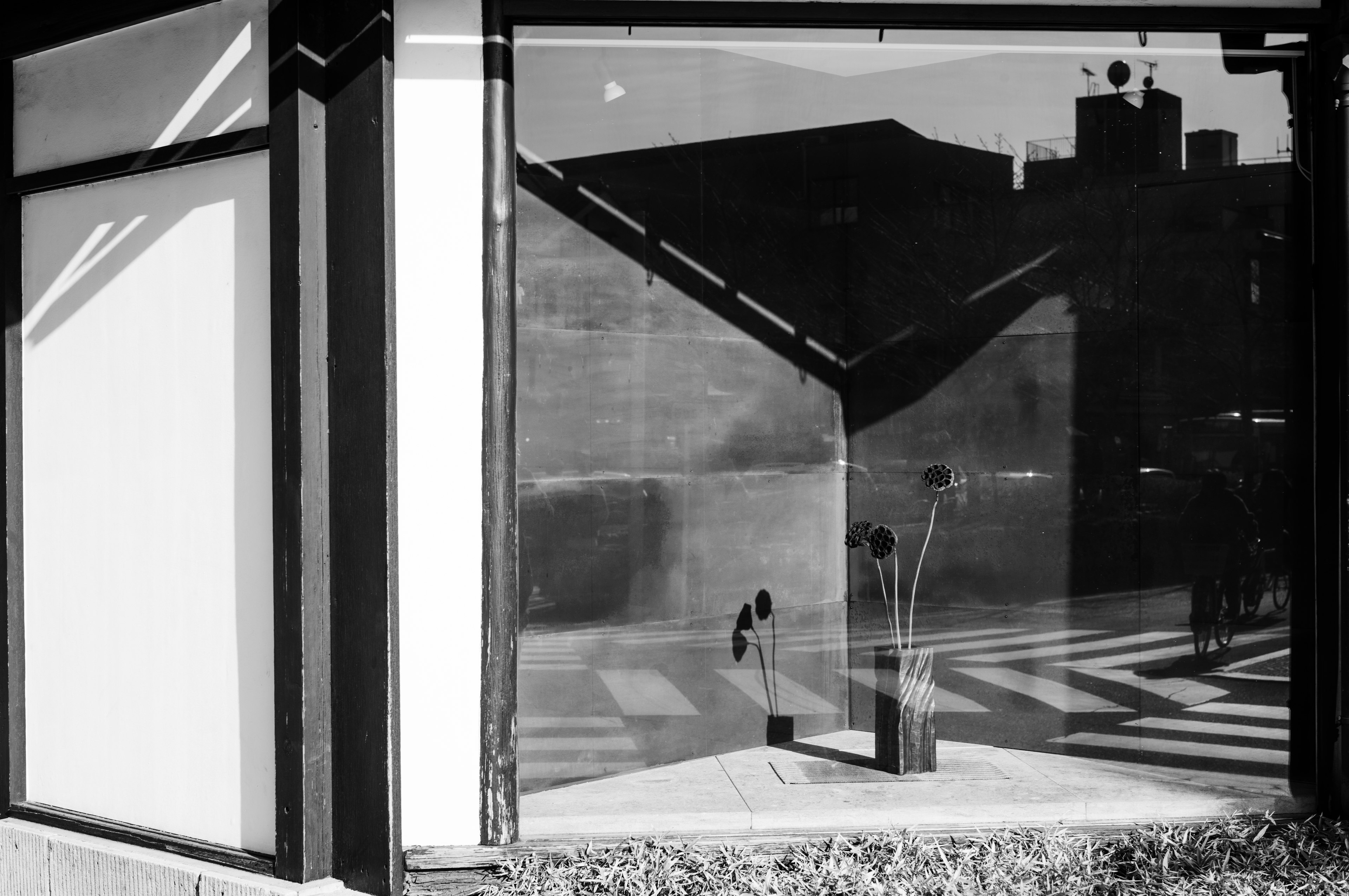 Reflejo en blanco y negro de una ventana que muestra un diseño arquitectónico lineal