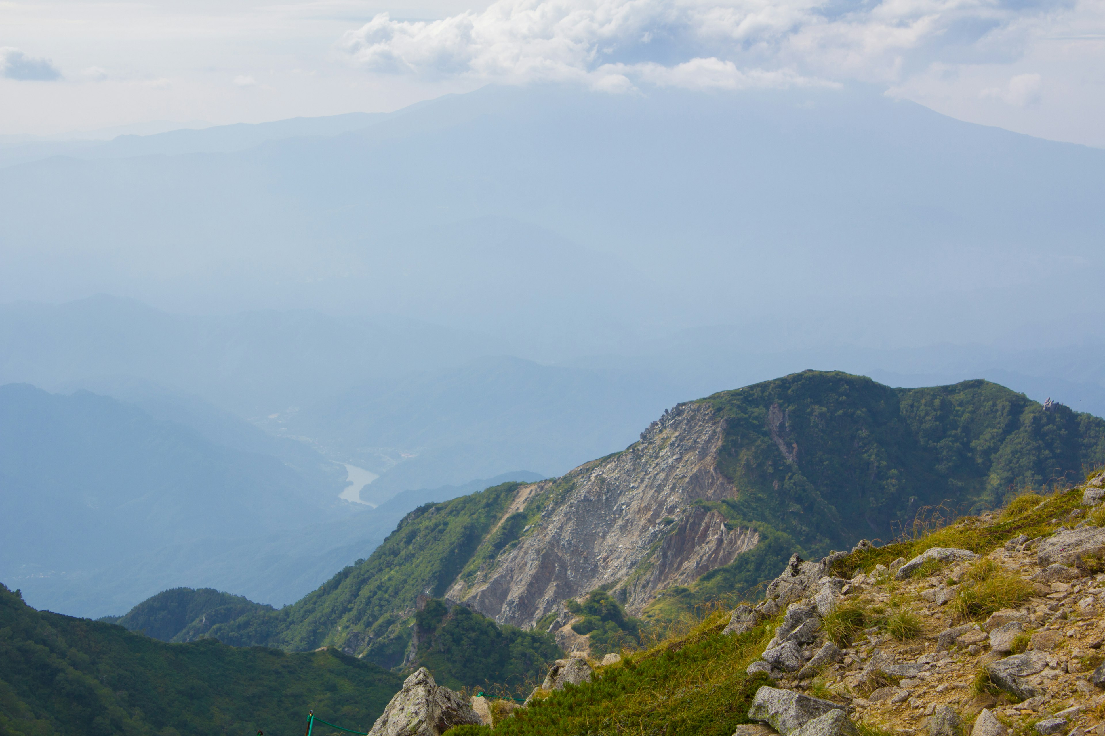 Paesaggio montano con vista nebbiosa sotto un cielo blu