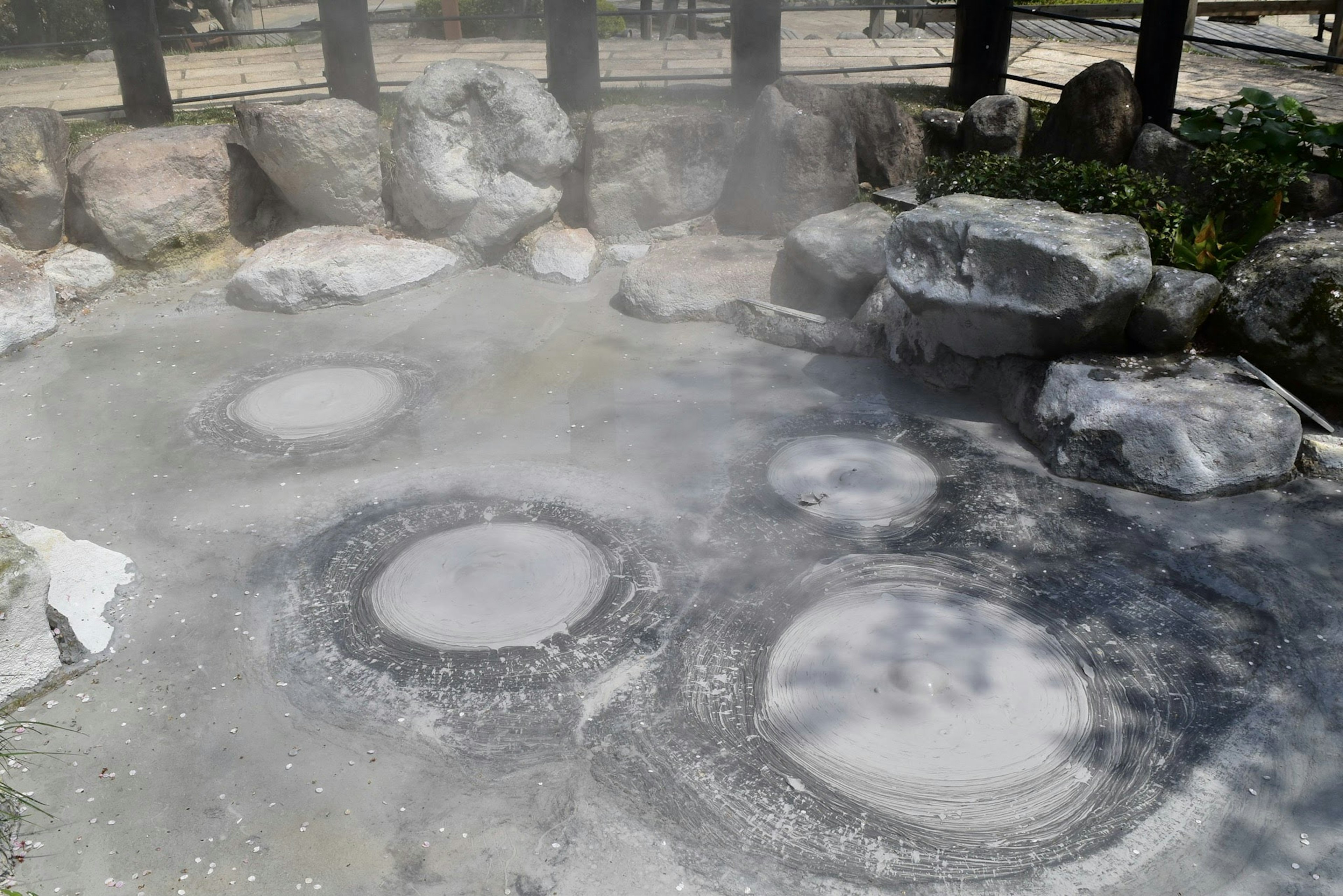 温泉の湯気が立ち上る石の周りにある温泉