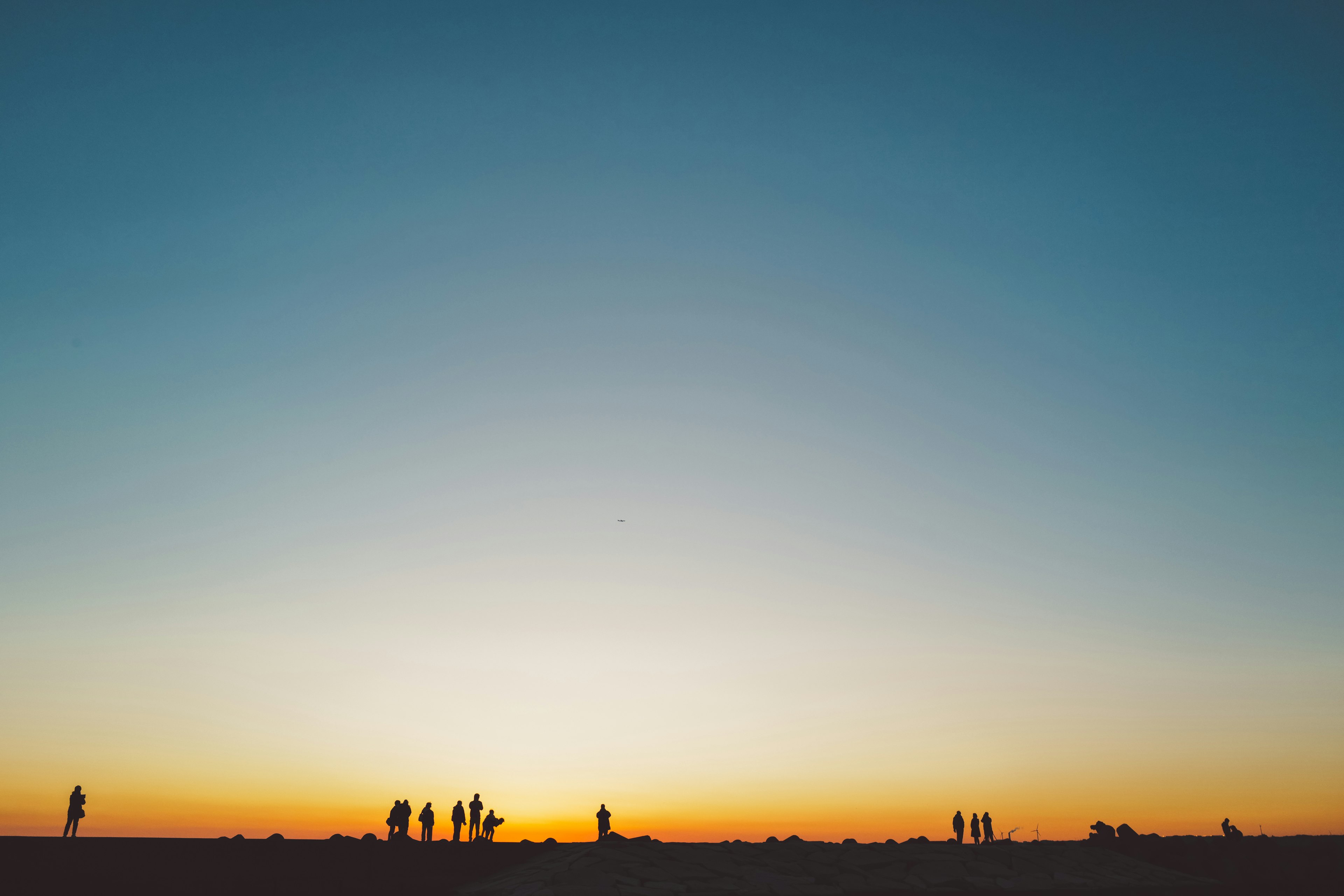 夕暮れ時の空とシルエットの人々