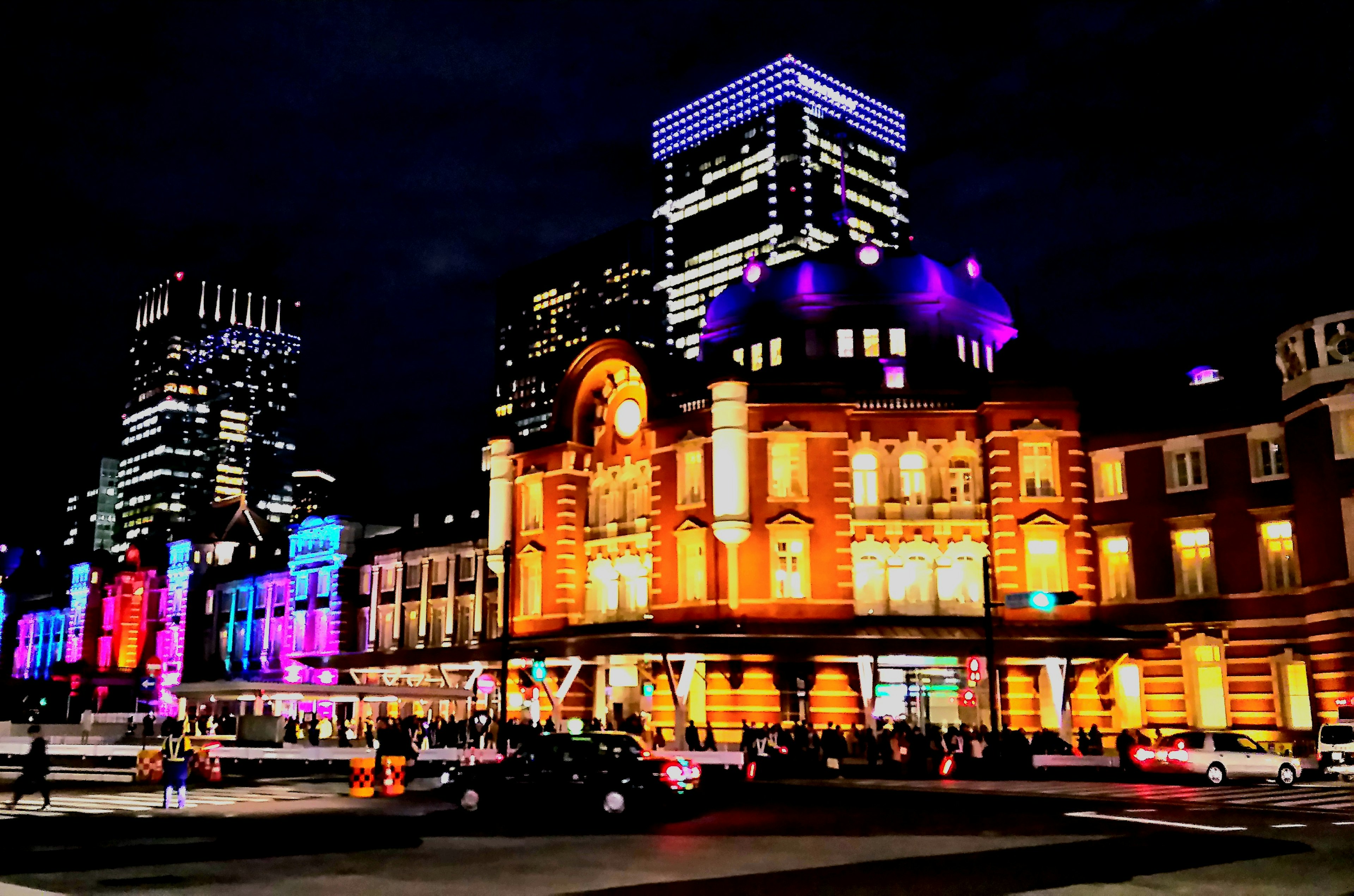 Vista notturna della stazione di Tokyo con edifici illuminati colorati