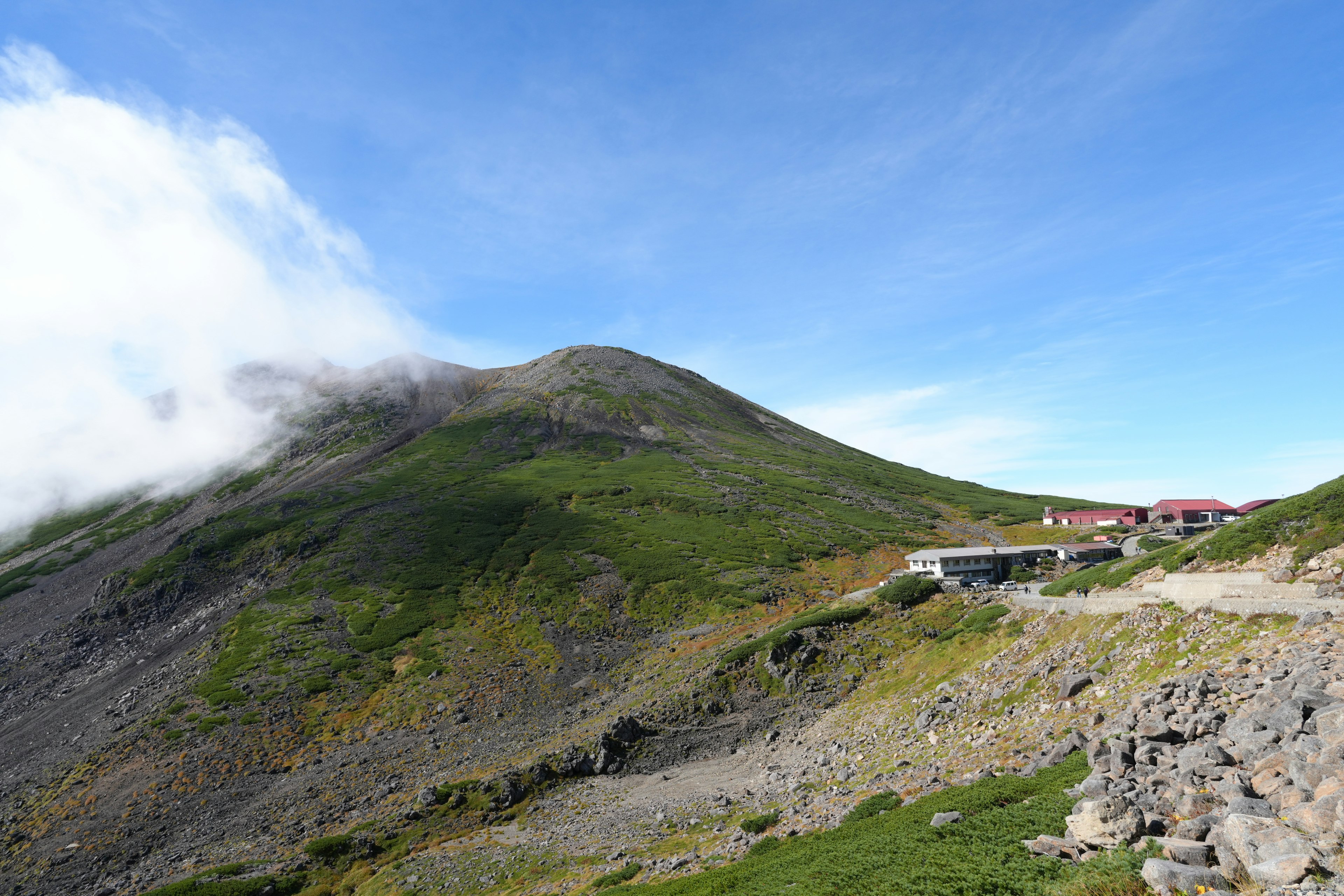 山の緑と青空に囲まれた風景と山小屋