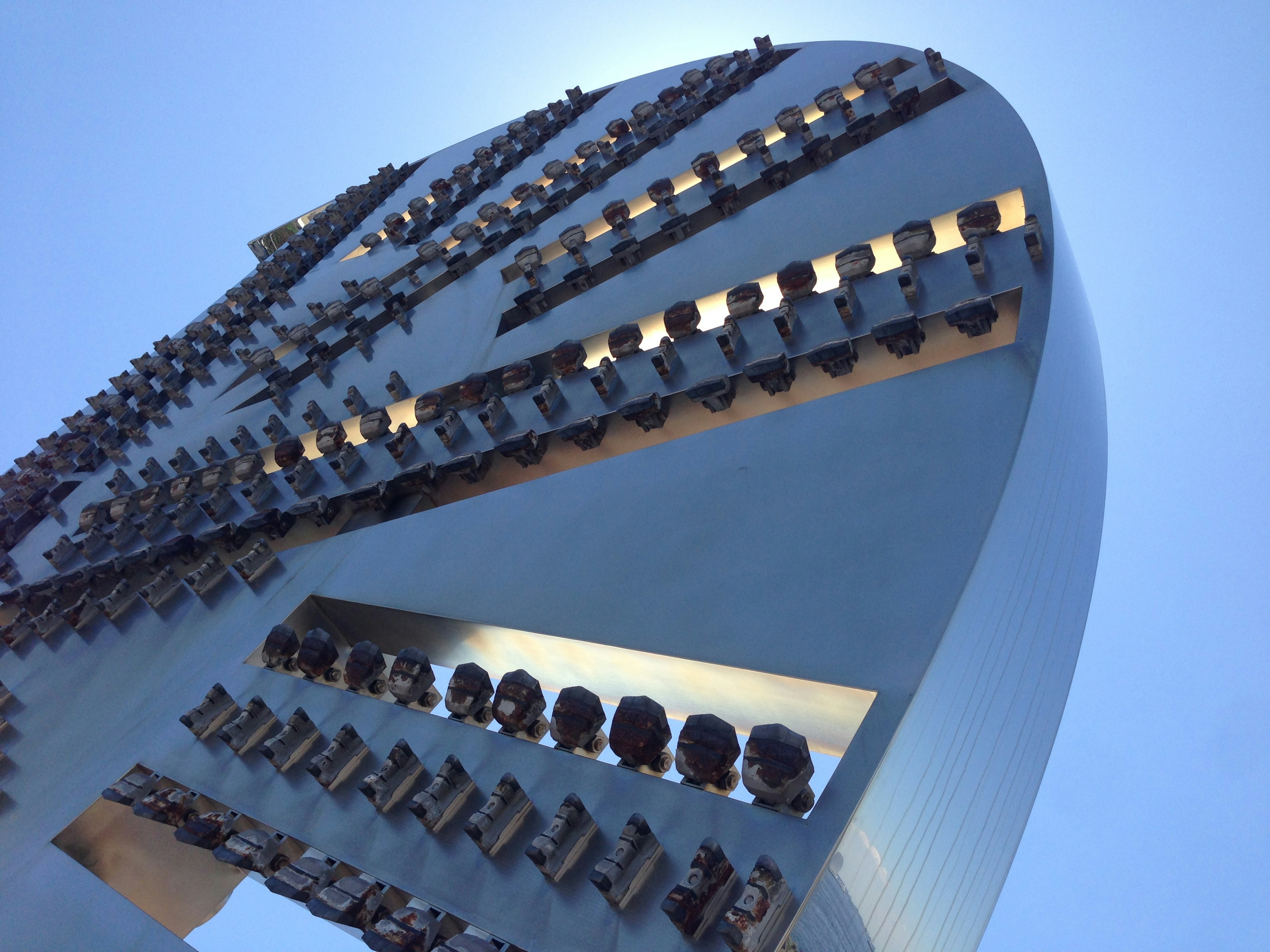 Escultura de metal con una forma única bajo el cielo azul