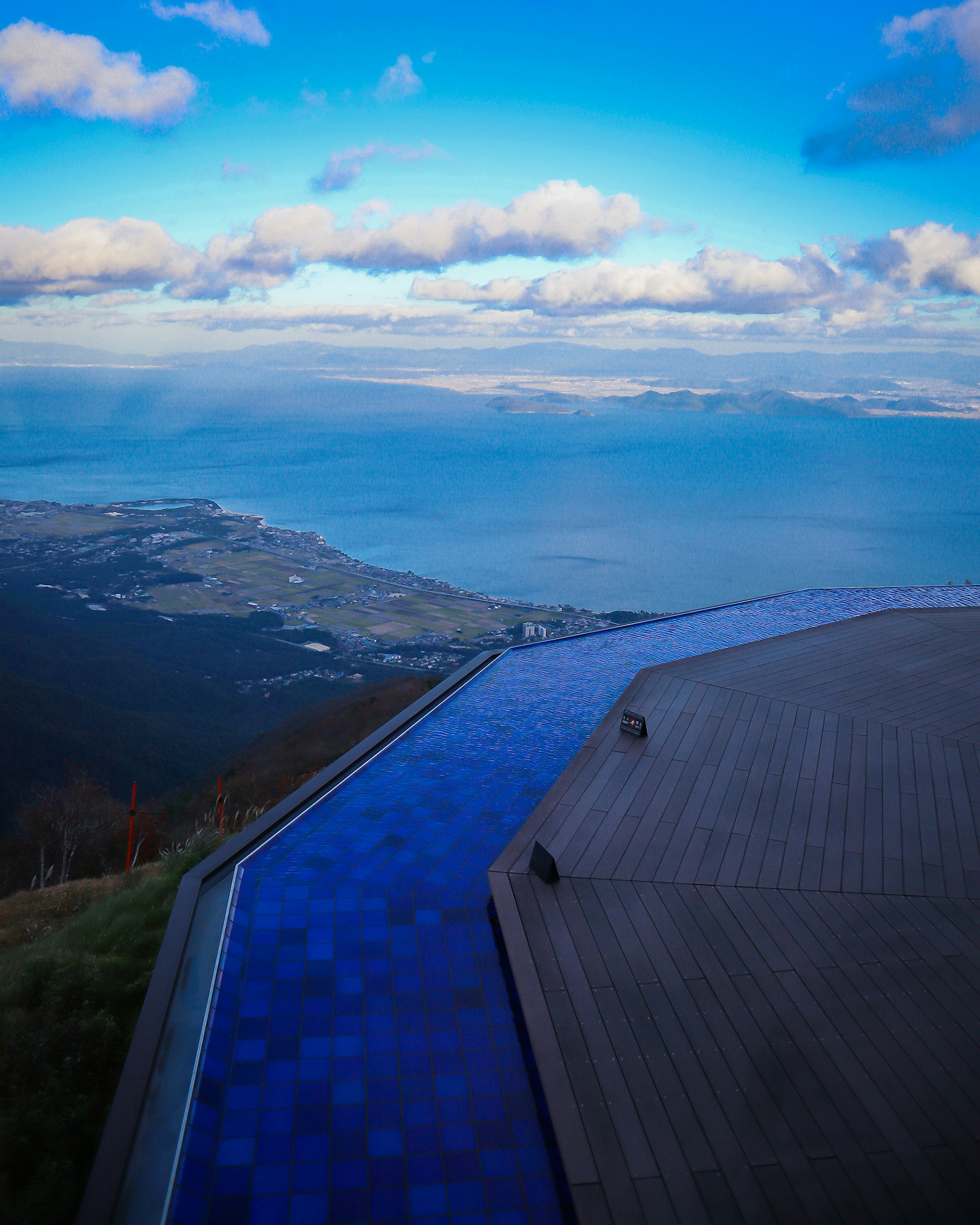 Pemandangan dari puncak gunung dengan kolam infinity dan langit biru