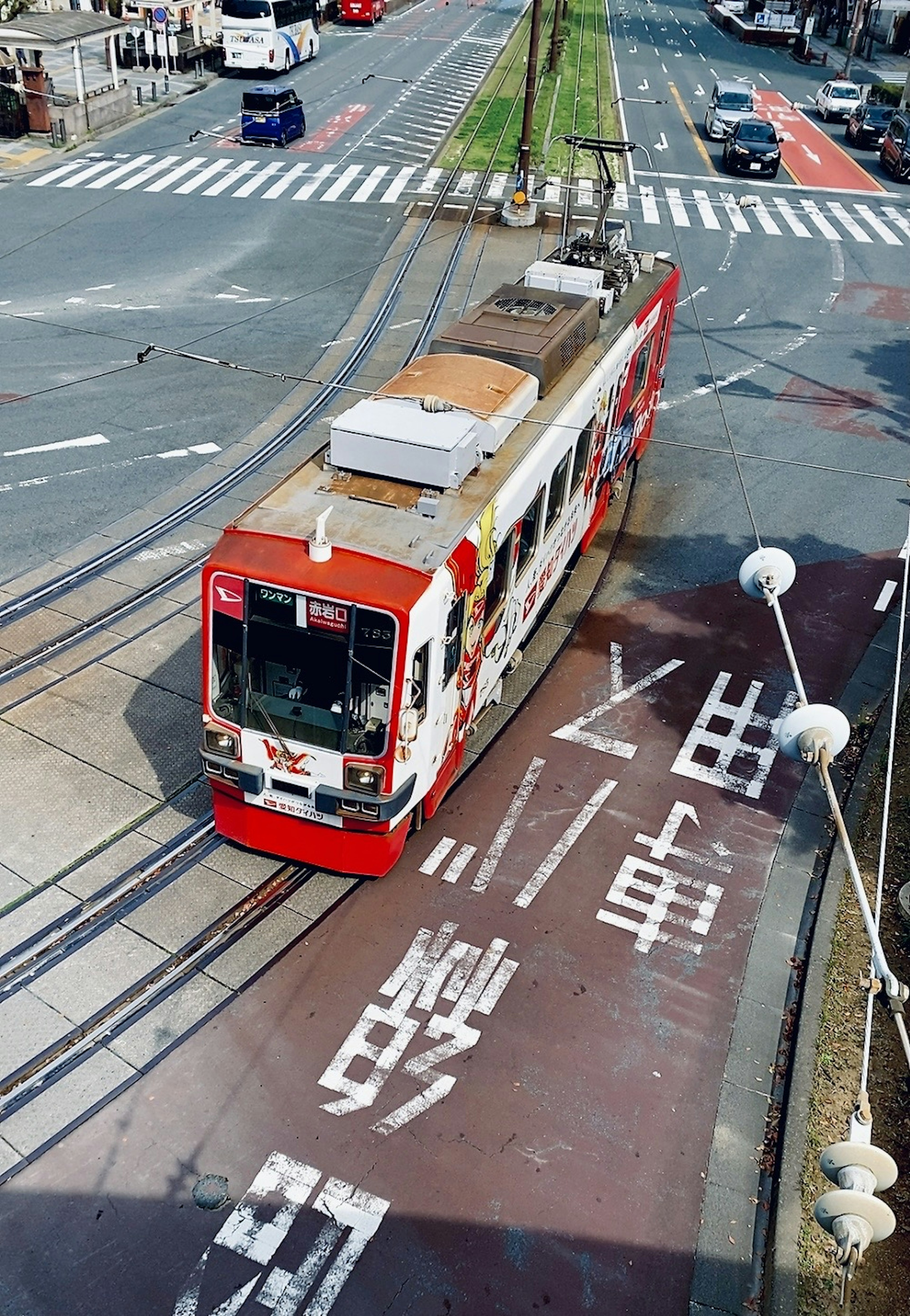 Rote Straßenbahn, die eine Kreuzung überquert