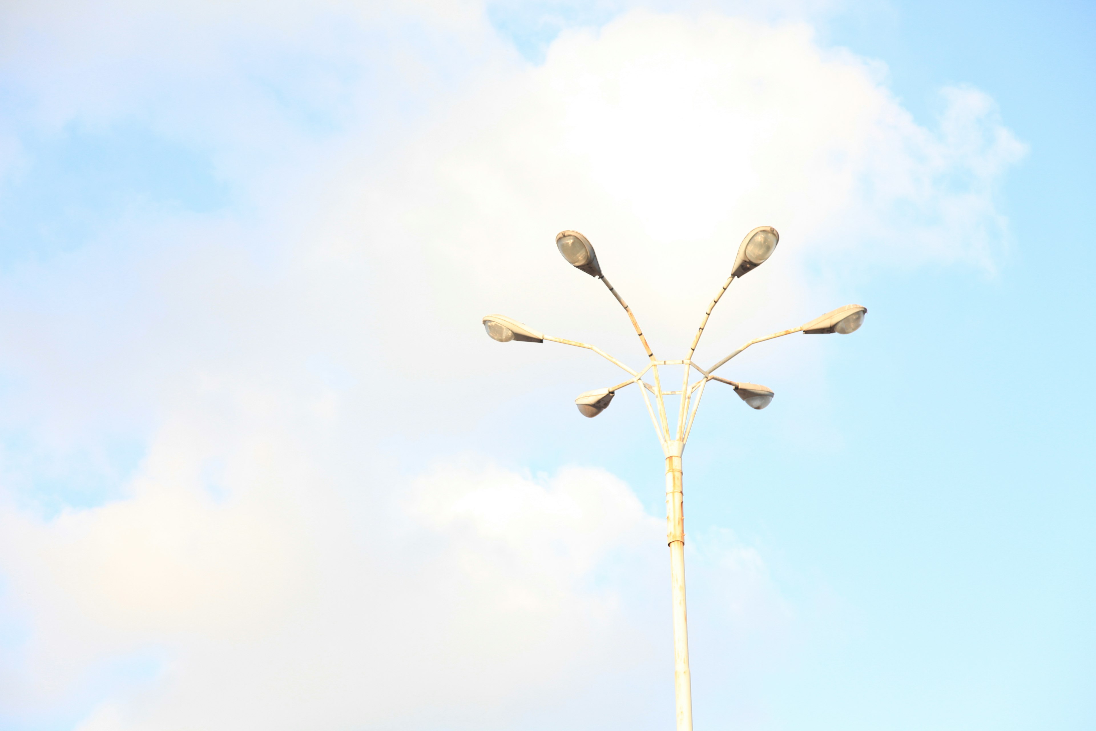 Multiple streetlights under a blue sky