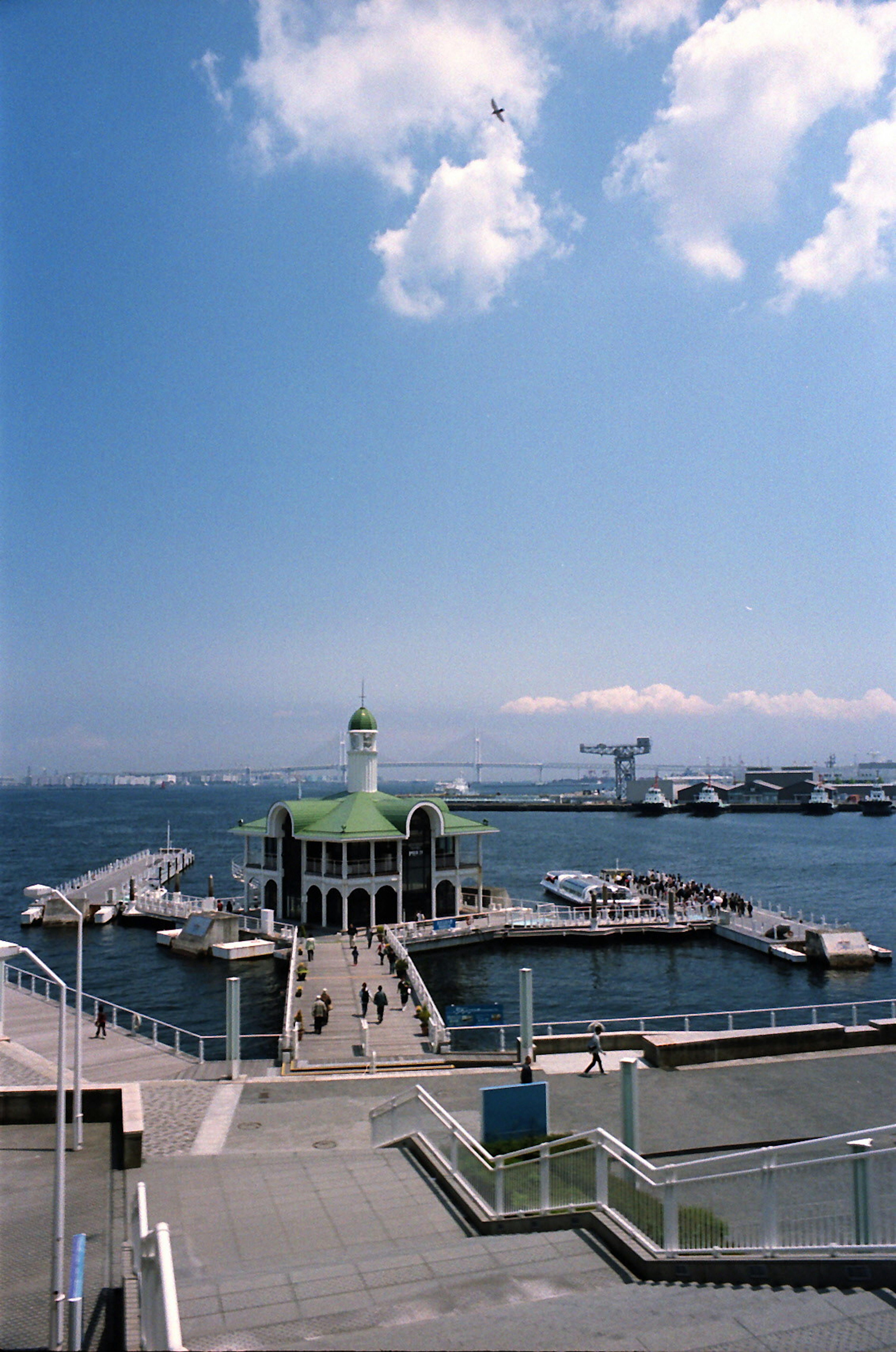 Harbor with green-roofed building under blue sky