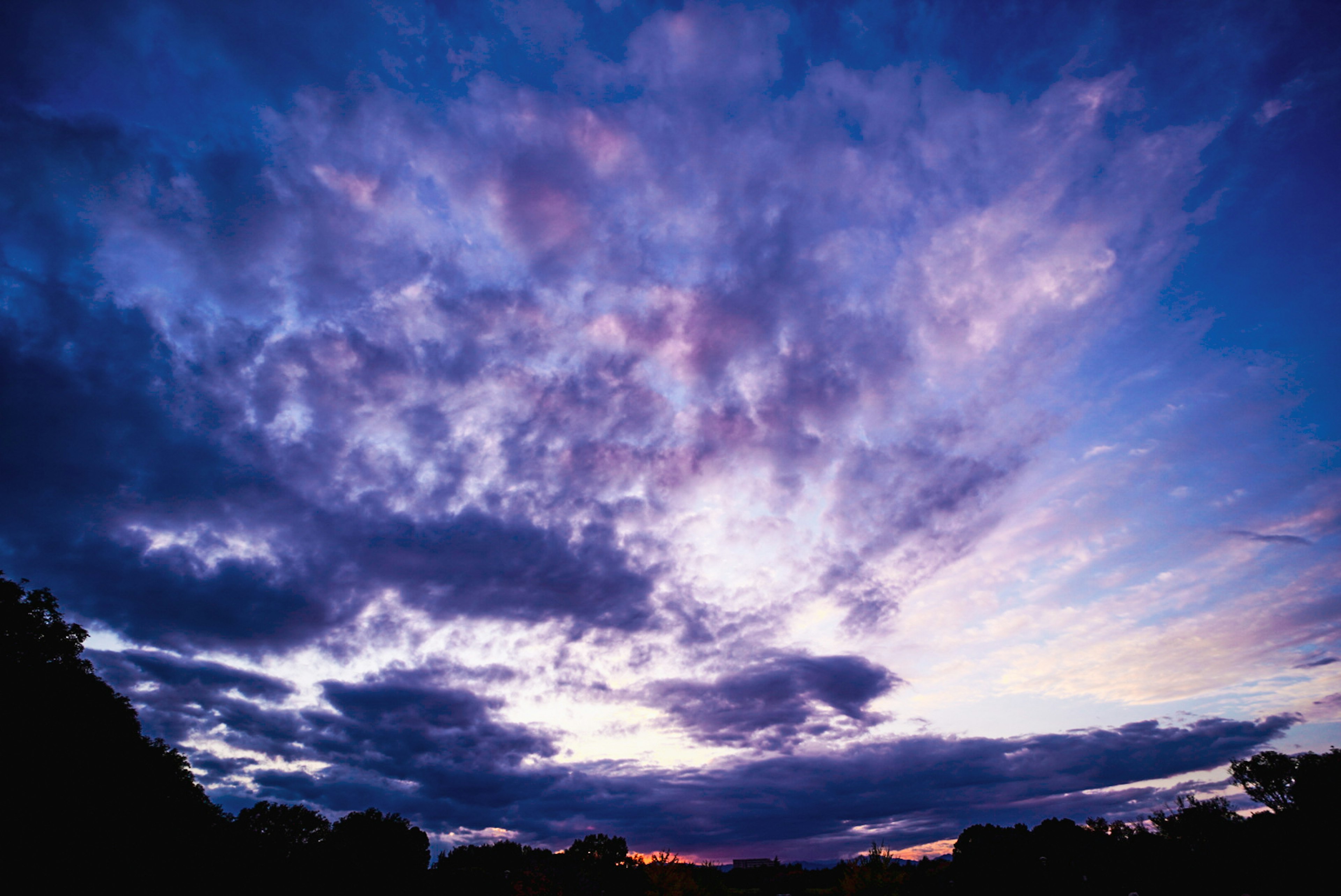 色とりどりの雲に覆われた夕焼けの空