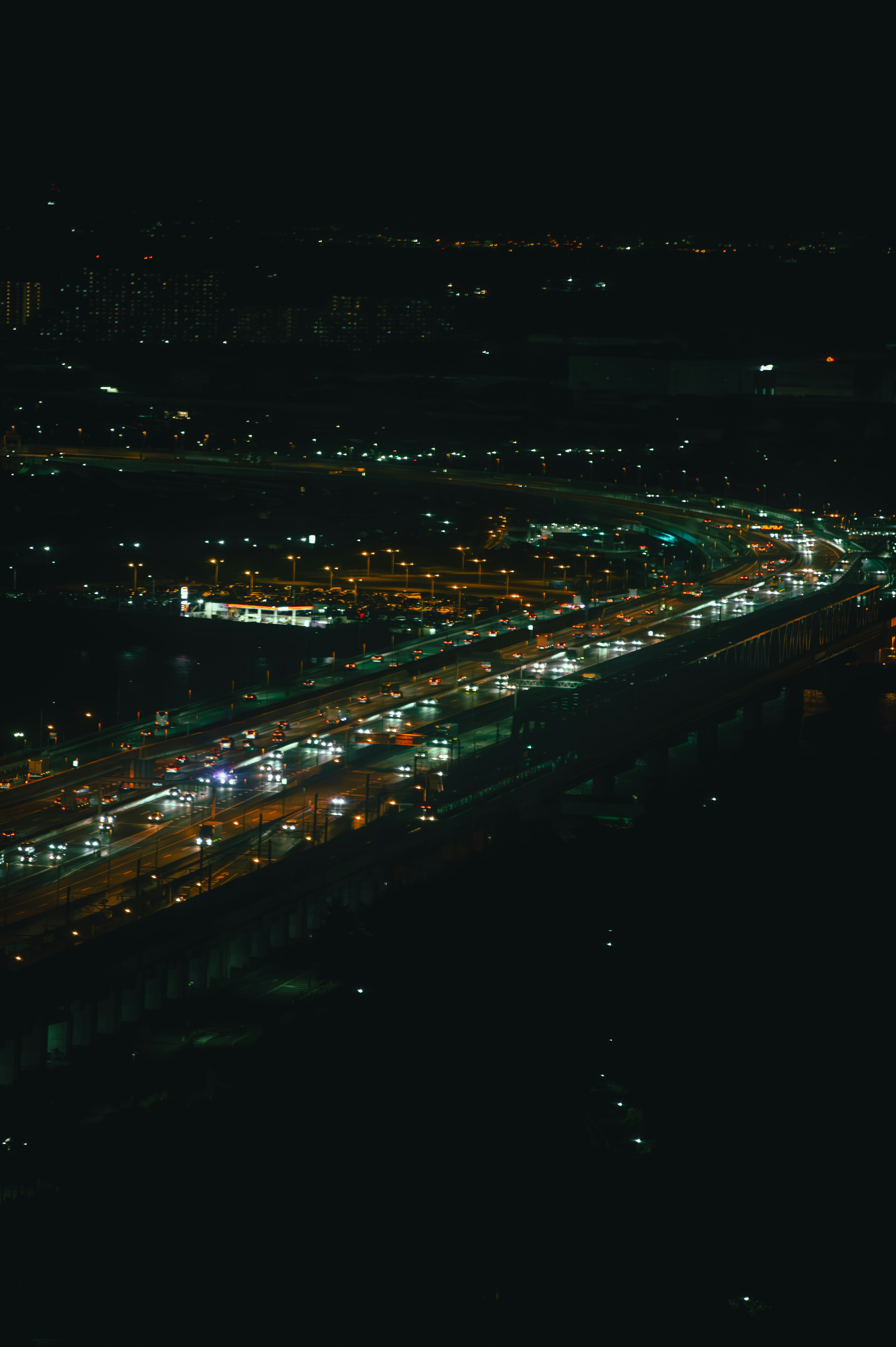 Aerial view of a city road illuminated at night with moving traffic