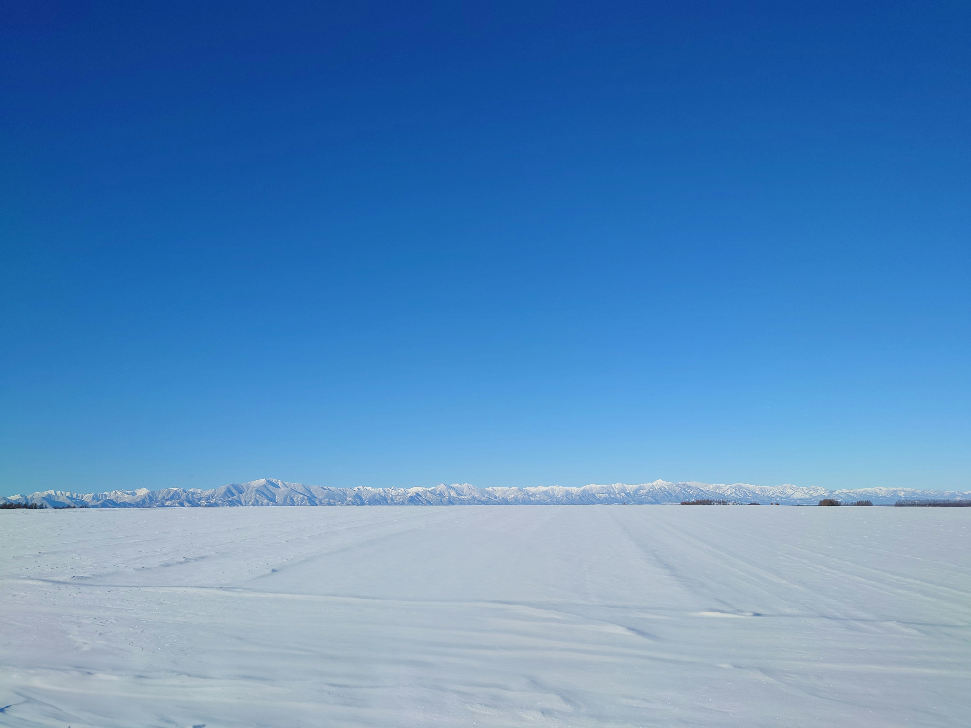 Vasto paesaggio innevato sotto un cielo blu